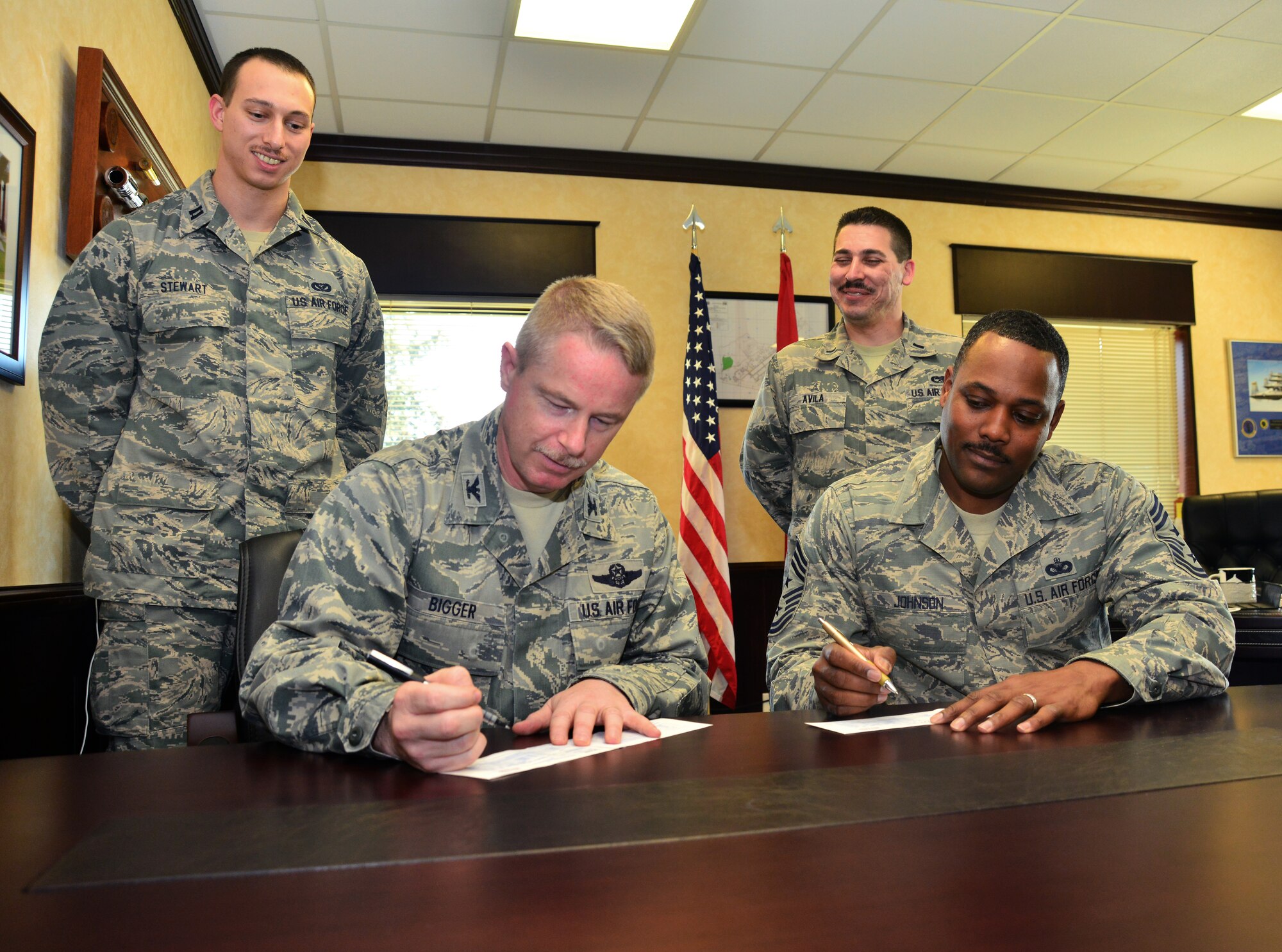 Col. Brent Bigger, 39th Air Base Wing vice commander, and Chief Master Sgt. Anthony Johnson, 39th ABW command chief, sign pledge forms to kick off the 2013 Air Force Assistance Fund campaign March 24, 2014, Incirlik Air Base, Turkey. This year marks the 41st anniversary of Airmen helping Airmen through the AFAF. The AFAF campaign "Commitment to Caring" runs through May 2, here and anyone may contribute to any of the four charities. (U.S. Air Force photo by Staff Sgt. Eric Summers Jr./Released)
