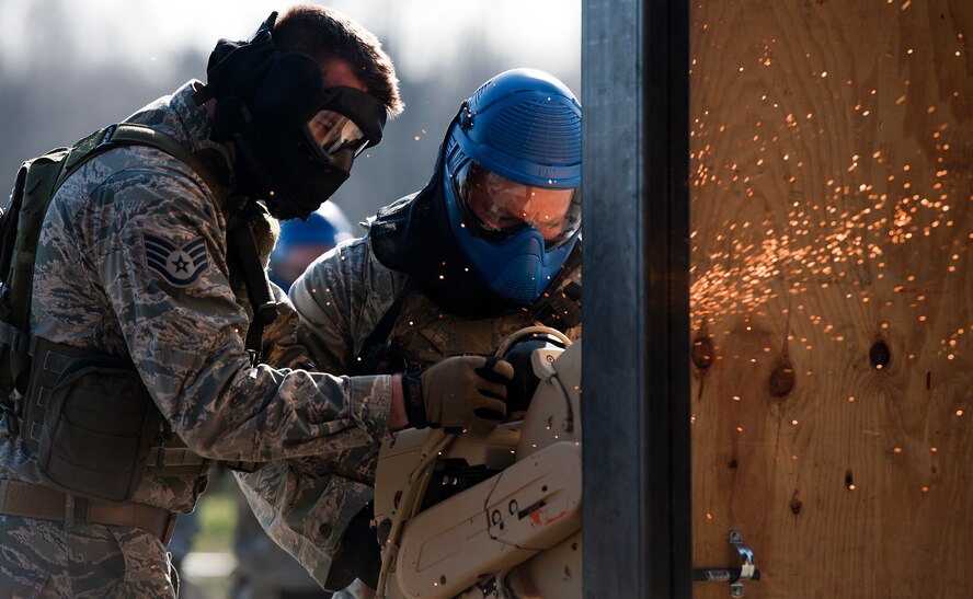 Staff Sgt. Cliff Coppenbarger (left), 435th Security Forces Squadron cadre, assists Staff Sgt. Brandon Burress, 701st Munitions Support Squadron custody forces member, breach a door during the Battlefield Leaders, Assaulters Course, March 11, 2014, Ramstein Air Base, Germany. Members of the 435th SFS taught Airmen a variety of skills during the course, including advance tactics, shooting and leadership. (U.S. Air Force photo/Senior Airman Damon Kasberg)