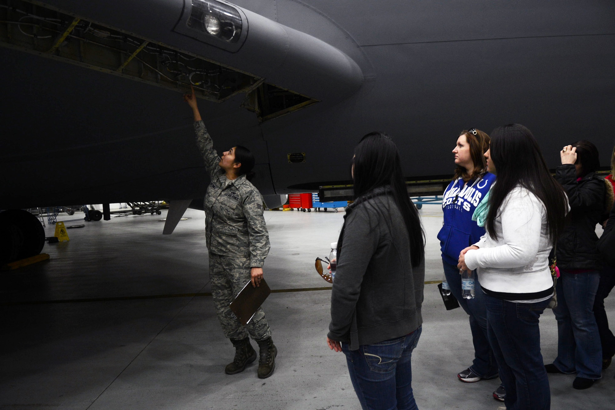 U.S. Air Force Senior Airman Alexis Martinez, 100th Aircraft Maintenance Squadron aircraft maintenance journeyman from Los Angeles, gives a tour of an isochronal inspection to squadron spouses March 21, 2014, on RAF Mildenhall, England. The spouses observed an aircraft currently undergoing maintenance and the work that is involved to get an aircraft ready to fly. (U.S. Air Force photo by Airman 1st Class Kyla Gifford/Released)