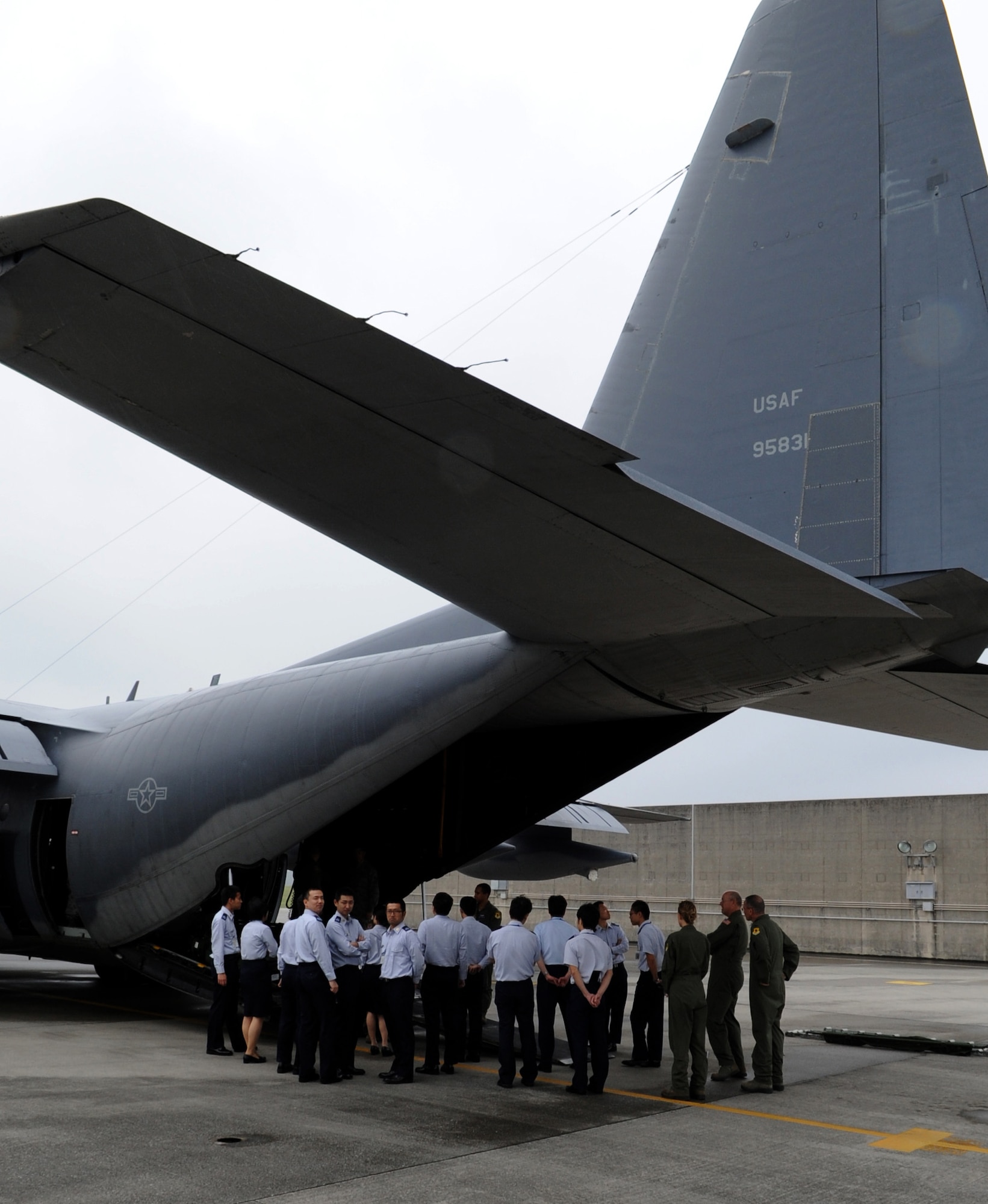 Members of the Japan Air Self Defense Force view a static display of a C-130 Hercules during a tour of Kadena Air Base Japan, March 20, 2014. The JASDF members learned about the 18th Aeromedical Evacuation Squadron mission and how they conduct their mission on two aircrafts stationed here, the KC-135 Stratotanker and C-130 Hercules. (U.S. Air Force photo by Airman 1st Class Keith James)