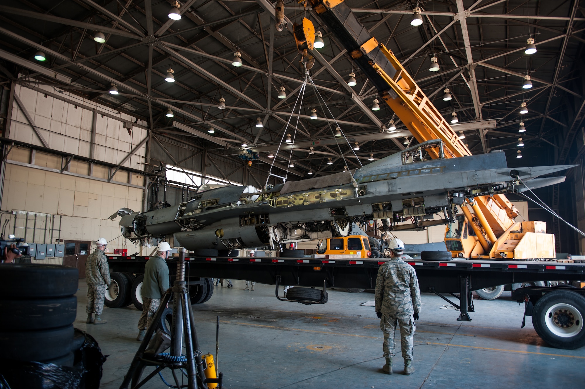 Airmen from the 8th Maintenance Squadron guide a damaged F-16 onto a flatbed truck at Kunsan Air Base, Republic of Korea, Mar. 22, 2014. The crash recovery team chiefs were recertified and trained on damaged aircraft equipment for disposal. (U.S. Air Force photo by Staff Sgt. Clayton Lenhardt/Released)
