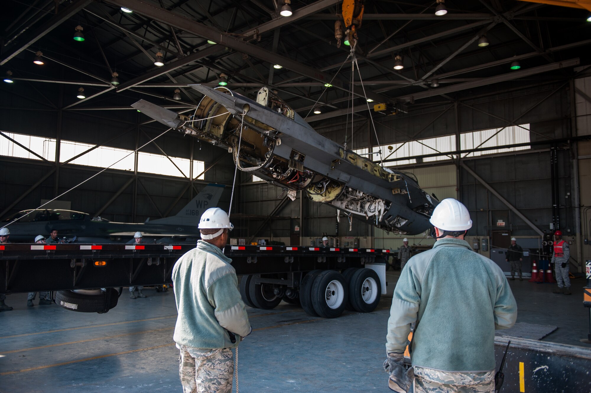 Airmen from the 8th Maintenance Squadron guide a damaged F-16 onto a flatbed truck at Kunsan Air Base, Republic of Korea, Mar. 22, 2014. The crash recovery team chiefs were recertified and trained on damaged aircraft equipment for disposal. (U.S. Air Force photo by Staff Sgt. Clayton Lenhardt/Released)
