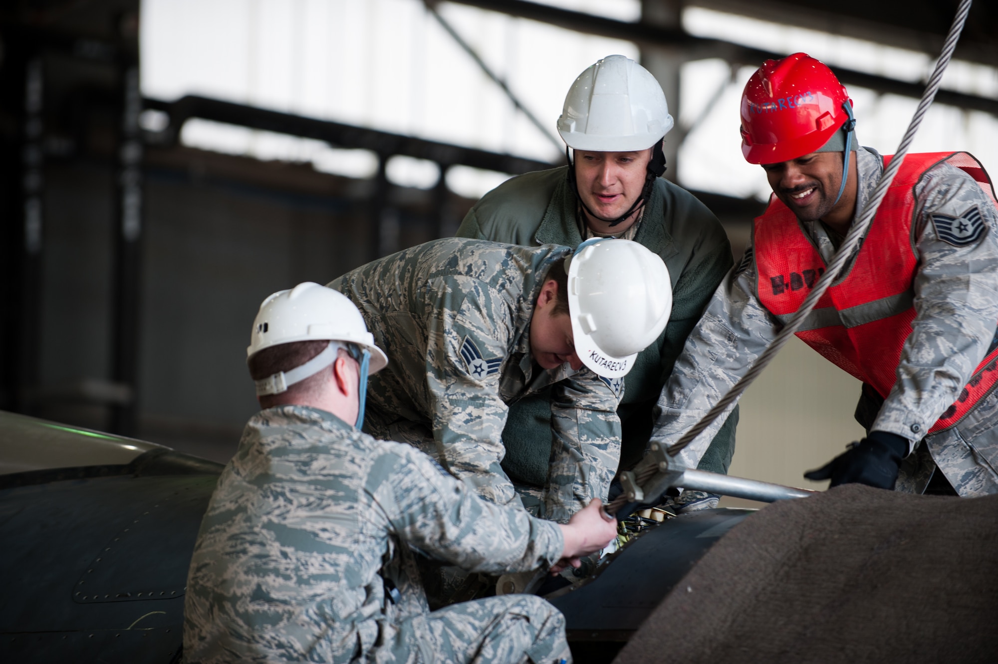 Airmen from the 8th Maintenance Squadron attach a crane hook to a damaged F-16 at Kunsan Air Base, Republic of Korea, Mar. 22, 2014. The crash recovery team chiefs were recertified and trained on damaged aircraft equipment for disposal. (U.S. Air Force photo by Staff Sgt. Clayton Lenhardt/Released)