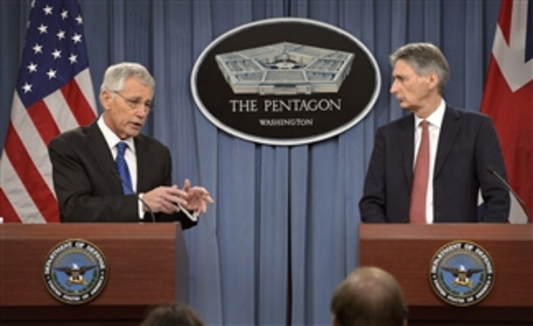 U.S. Defense Secretary Chuck Hagel, left, and British Defense Secretary Philip Hammond brief reporters during a joint news conference at the Pentagon, March 26, 2014. The two defense leaders answered questions on a range of issues, including the situation in Ukraine and search efforts for missing Malaysia Airlines Flight 370.
