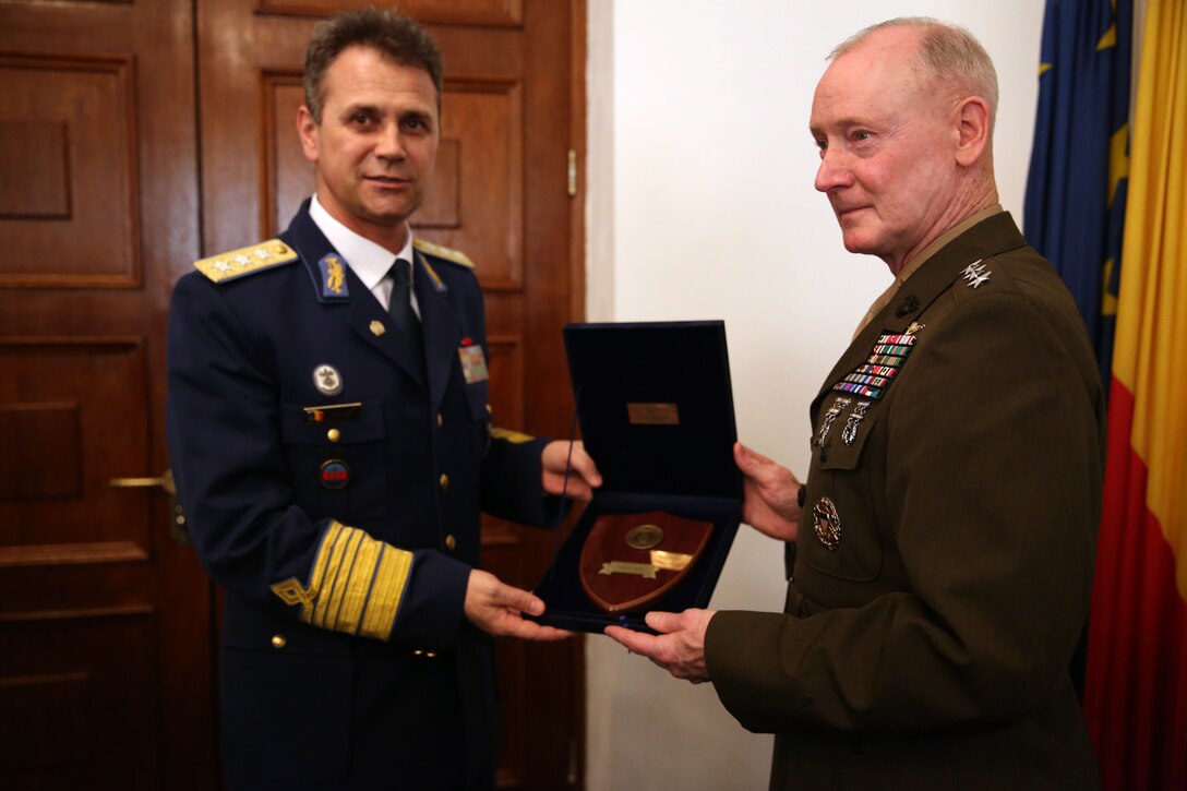 Romanian Lt. Gen. Stefan Danila, Chief of Romanian general staff, presents a gift to U.S. Marine Corps Lt. Gen. Richard Tryon, commander of U.S. Marine Corps Forces Command and U.S. Marine Corps Forces, Europe, after their meeting in Bucharest, March 18, 2014. Tryon visited with Romanian military officials to discuss continuing the good military relationship between the United States and Romania. United States military forces are currently in Romania assigned to Mihail Kogalniceanu Air Base and the two nations work together during much of the Black Sea Rotational Force deployment. Black Sea Rotational Force 14 is a contingent of Marines and sailors tasked with maintaining positive relations with partner nations, regional stability and increasing interoperability while providing the capability for rapid crisis response, as directed by U.S. European Command, in the Black Sea, Balkan and Caucasus regions of Eastern Europe. (Official Marine Corps photo by Lance Cpl. Scott W. Whiting, BSRF PAO/ Released)