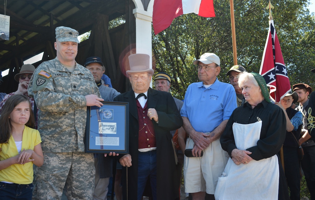 Lt. Col. Chris Tande, a contacting team leader with the U.S. Army Corps of Engineers Sacramento District, presents a token of thanks to members of the Knights Ferry History and Museum Associates for their continued support at the Corps’ Stanislaus River Parks in Knights Ferry, Calif., March 22, 2014. From left to right are Lt. Col. Tande; Lee Shearer, KFHMA vice-president; James McCarthy, and Sherron McCarthy, KFHMA president. Sacramento District employees and hundreds of history buffs gathered in Knights Ferry to officially commemorate attaining National Historic Landmark status for the 300-foot-long covered bridge in the historic 19th-century township.