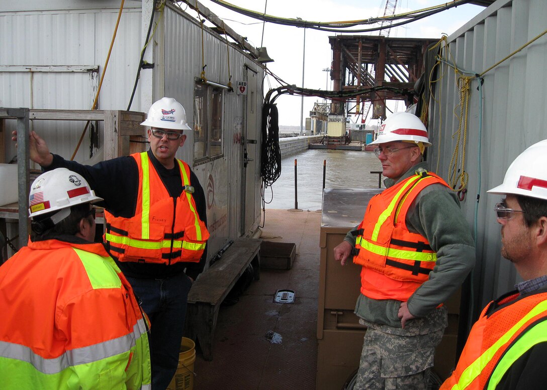 USACE Command Sgt. Maj. Karl J. Groninger discusses diving conditions and operations at Olmsted Locks and Dam on the lower Ohio River. From left to right, Mark Wise, Olmsted lead dive inspector; Nick Finney, Global Diving lead diving supervisor; Groninger; and Scott Hearne, Olmsted cheif of quality assurance.