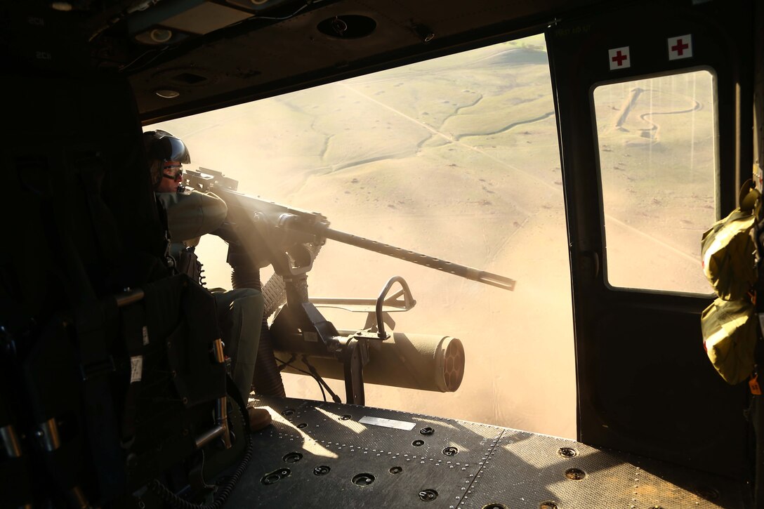 Gunnery Sgt. Kenneth T. Deal with Marine Medium Tiltrotor Squadron 163 (reinforced), 11th Marine Expeditionary Unit, fires a GAU-21 .50-caliber machine gun as part of a simulated tactical air control party (TACP) exercise during Realistic Urban Training Marine Expeditionary Unit Exercise 14-1 (RUTMEUEX) at Camp Roberts, Calif., March 26, 2014.  RUTMEUEX will prepare the 11th MEU Marines for their upcoming deployment, enhancing their combat skills in environments similar to those they may find in future missions.  (U.S. Marine Corps photo by Lance Cpl. Laura Y. Raga/Released)