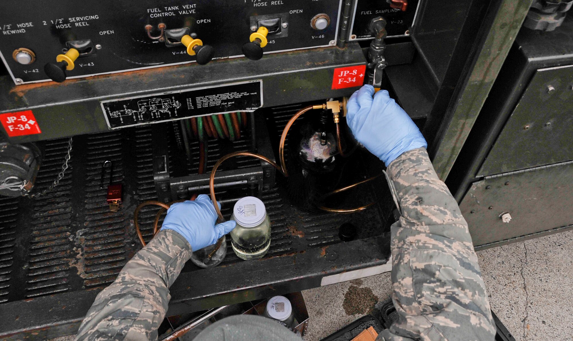 U.S. Air Force Airman 1st Class Zachary Campbell, 35th Logistics Readiness Squadron fuels distribution operator, funnels JP-8 fuel into a container at Misawa Air Base, Japan, March 25, 2014. The jet fuel in these trucks is delivered 17 miles underground via two, four-inch wide pipes to Misawa Air Base from Hachinohe city. (U.S. Air Force photo/Airman 1st Class Patrick S. Ciccarone)