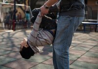 Staff Sgt. Matthew Folendore, 51st Comptroller Squadron noncommissioned officer in charge of relocations at Osan Air Base, Republic of Korea, flips a kid while playing March 22, 2014, at the Aehyang Child Welfare Center in Pyeongtaek. More than 60 orphans played with airmen from Osan Air Base during the visit. The Aehyang CWC director said the children were thrilled to visit with the airmen, and they look forward to seeing them again. (U.S. Air Force photo by Staff Sgt. Jake Barreiro)