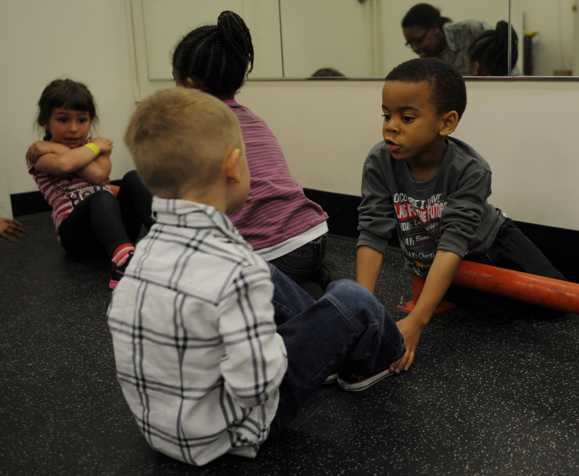 Two children from the base Youth Center do sit-ups at Mountain Home Air Force Base, Idaho, March 27, 2014. The children participated in a physical fitness challenge where they performed sit-ups and push-ups for 30 seconds. A 200 meter run was the last event of the challenge. (U.S. Air Force Photo by Airman 1st Class Brittany A. Chase/Released)