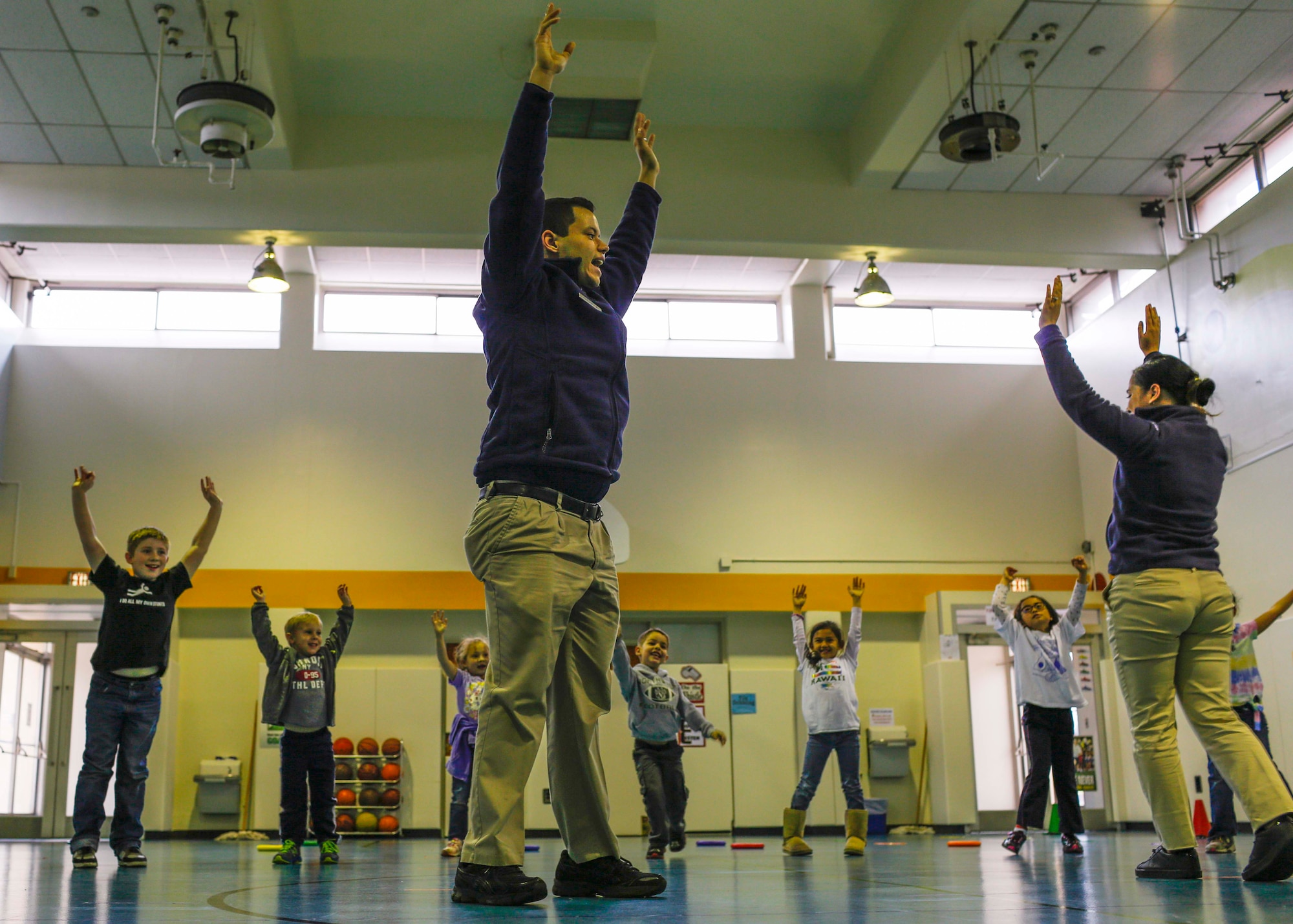 Airman 1st Class Emmanuel Jacobs and Michelle Jacobs, 374 Force Support Squadron fitness specialists, teach Yokota West elementary school students burpees on March 20, 2014, at Yokota Air Base, Japan.  The students completed a 10-week long fitness program, Club 2-1-5-0, which encouraged students to reduce their TV time to two hours, engage in physical activity for at least one hour, eat five servings of fruit and vegetables and to drink only zero calorie beverages.  (U.S. Air Force photo by Airman 1st Class Soo C. Kim / Released)