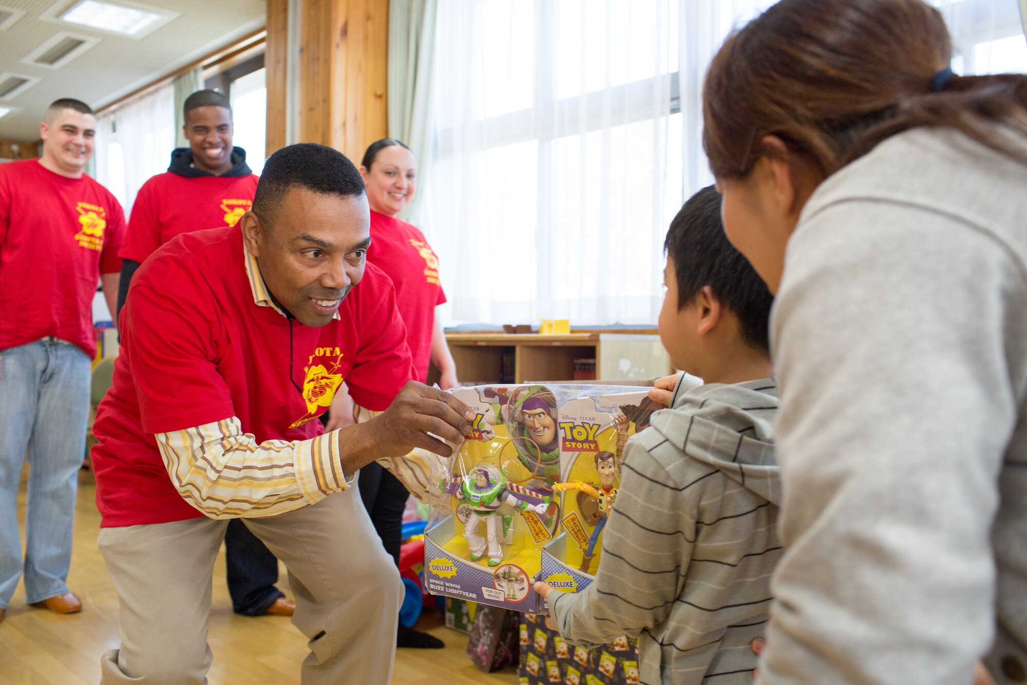 Danny Russell, 730th Air Mobility Squadron and former Marine Drill Instructor, presents a child with a toy at Ajiro orphanage in Akiruno city, Tokyo, March 24, 2014, during the annual Semper Fi Society’s Toy drop. Since 2012, Semper Fi Society has collected toys from “Toys for Tots” drives at Yokota Air Base and distributes them in the local Japanese community (U.S. Air Force photo by Osakabe Yasuo/Released)