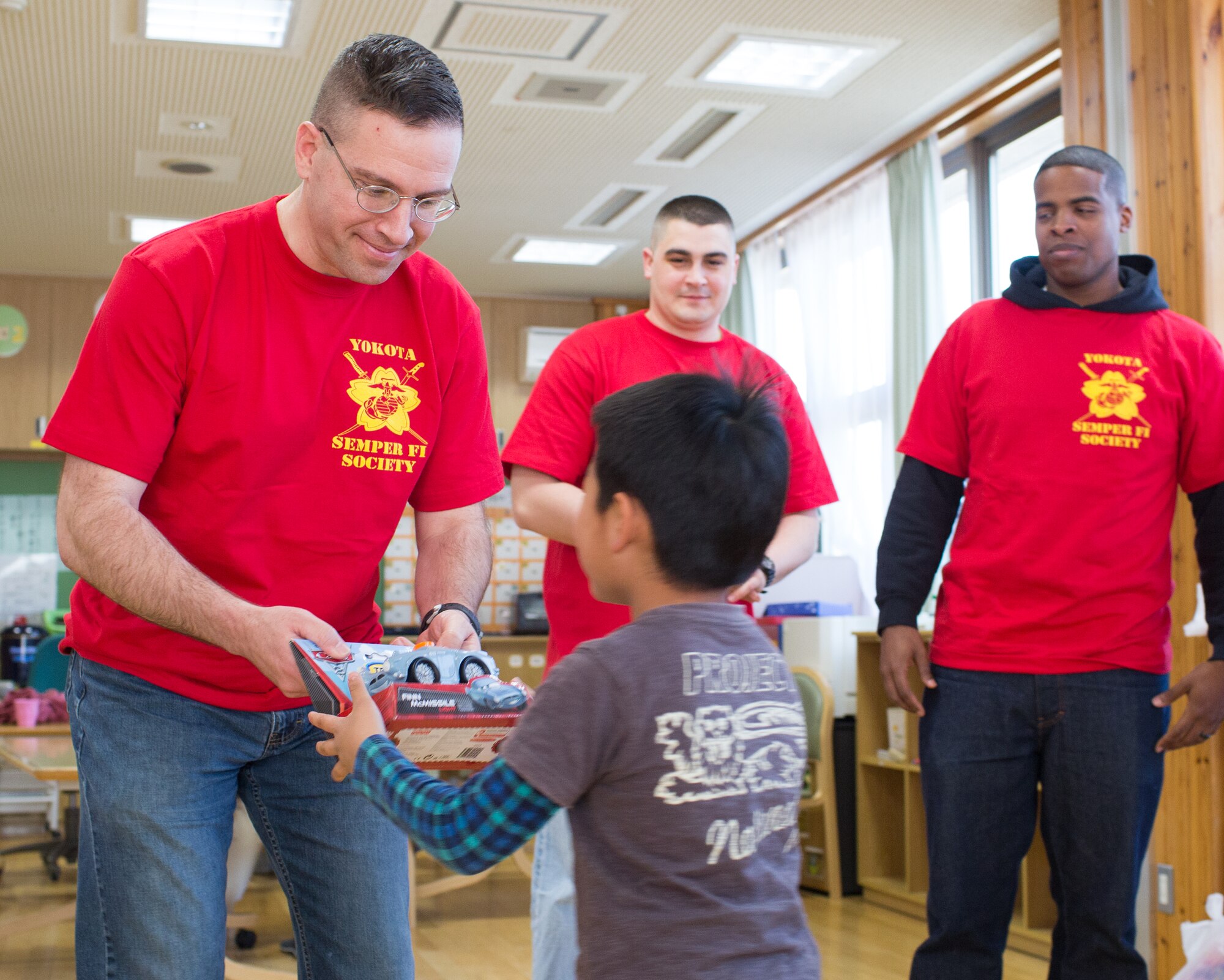 Marine Major Wade Evans, U.S. Forces Japan, presents a child with a toy at Ajiro orphanage in Akiruno city, Tokyo, March 24, 2014, during the annual Semper Fi Society’s toy drop. Since 2012, Semper Fi Society has collected toys from “Toys for Tots” drives at Yokota Air Base and distributes them in the local Japanese community (U.S. Air Force photo by Osakabe Yasuo/Released)
