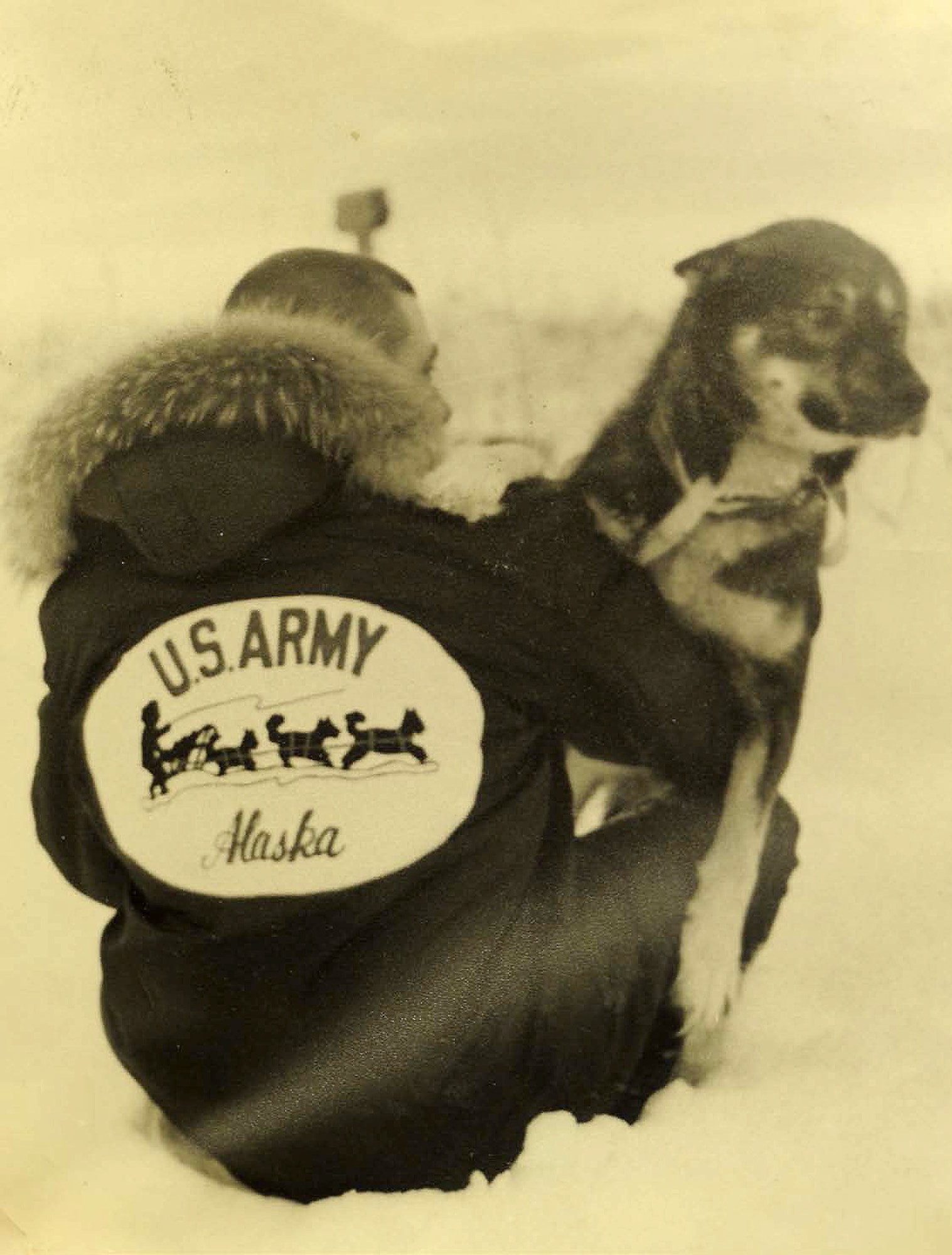 A member of the U.S. Army Alaska sled dog team rests with his dog circa 1965. (U.S. Army photo)