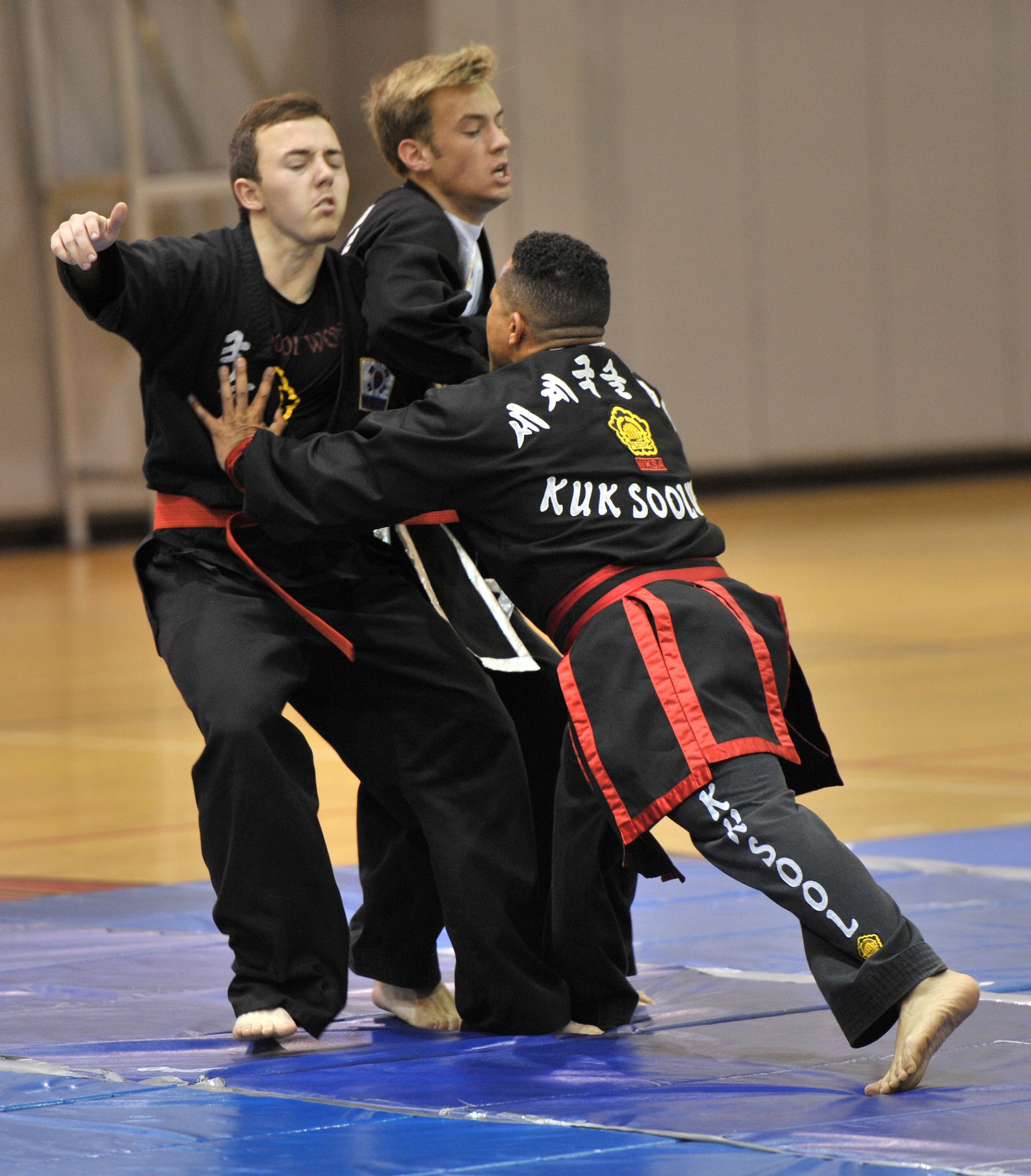 Retired Master Sgt. Amado Garcia, previously assigned to 96th Aircraft Maintenance Squadron, Eglin Air Force Base, Fla., forces back two opponents during a Kuk Sool Won Black Belt Demo at the Aderholt Fitness Center on Hurlburt Field, Fla, March 22, 2014. Kuk Sool Won is a traditional Korean martial art which uses techniques dating back more than 5,000 years. (U.S. Air Force photo/Senior Airman Kentavist P. Brackin) 