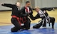 Retired Master Sgt. Amado Garcia, previously assigned to the 96th Aircraft Maintenance Squadron Eglin Air Force Base, Fla., disables two opponents with a joint lock technique during a Kuk Sool Won Black Belt Demo at the Aderholt Fitness Center on Hurlburt Field, Fla, March 22, 2014. Students of Kuk Sool Won learn restraining methods, joint-breaking and combination joint locking techniques. (U.S. Air Force photo/Senior Airman Kentavist P. Brackin) 