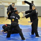 Sherwin Huegin executes a flying kick at a wooden board during a Kuk Sool Won Black Belt Demo at the Aderholt Fitness Center on Hurlburt Field, Fla, March 23, 2014. Huegin was one of two students promoted to 1st degree black belt during the demo. (U.S. Air Force photo/Senior Airman Kentavist P. Brackin) 