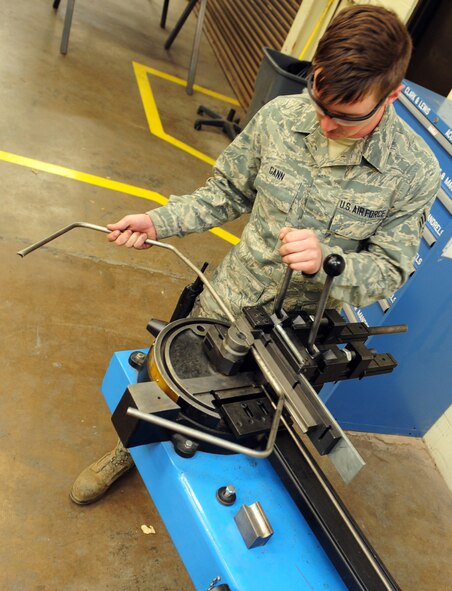 U.S. Air Force Senior Airman Tyler Gann, 7th Equipment Maintenance Squadron aircraft structural maintenance, bends a section of titanium tubing March 26, 2014, at Dyess Air Force Base, Texas. Titanium, stainless steel and aluminum tubes are precisely matched to damaged lines on the B-1B Lancer and C-130J that are being replaced to ensure a perfect fit when repairing the aircraft. (U.S. Air Force photo by Senior Airman Kia Atkins/Released)