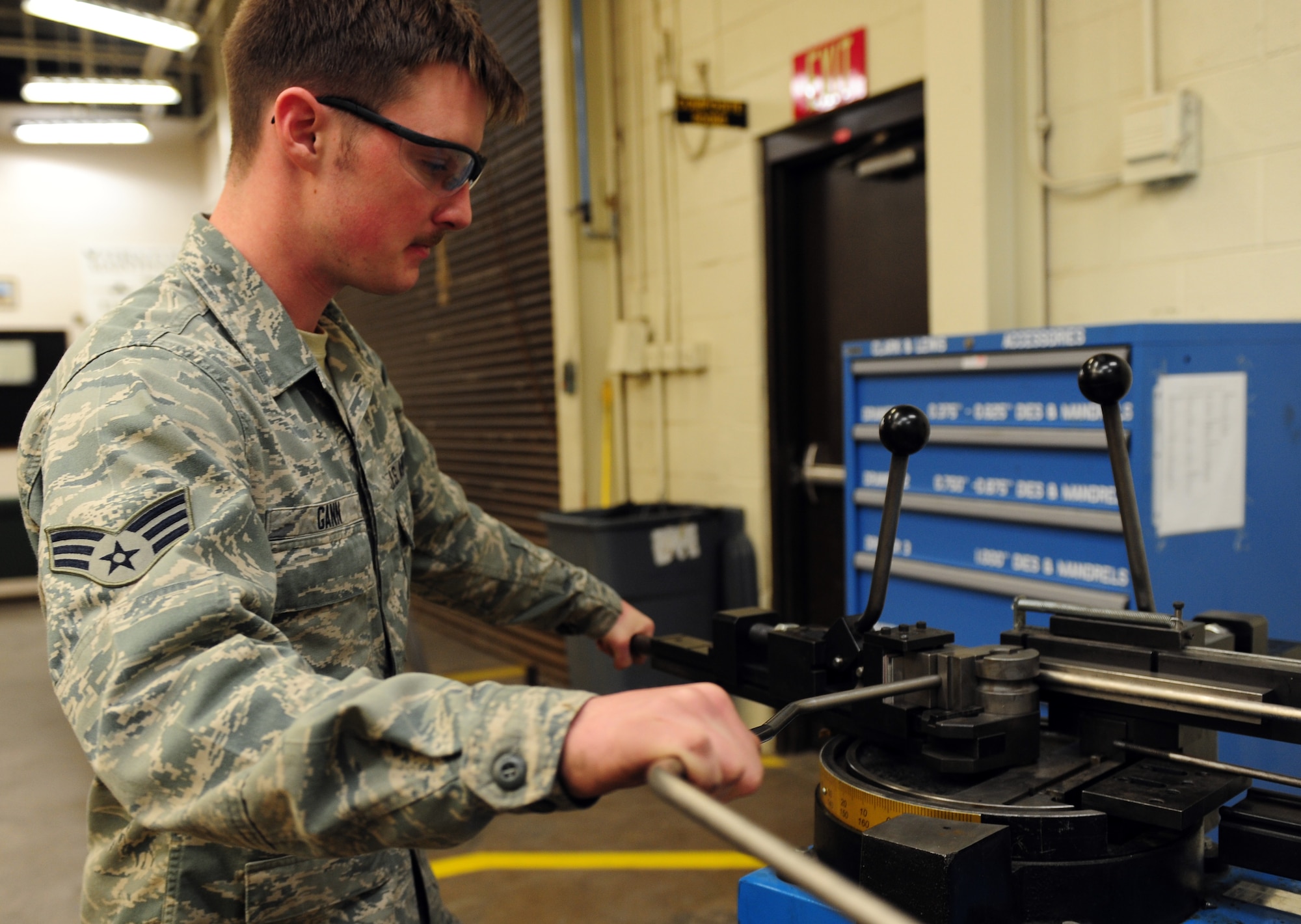 U.S. Air Force Senior Airman Tyler Gann, 7th Equipment Maintenance Squadron aircraft structural maintenance, bends a section of titanium tubing March 26, 2014, at Dyess Air Force Base, Texas. Because many companies no longer manufacture certain aircraft parts for the B-1B Lancer, Airmen from the 7th EMS have to make or refurbish old parts to replace those that have worn out. (U.S. Air Force photo by Senior Airman Kia Atkins/Released)