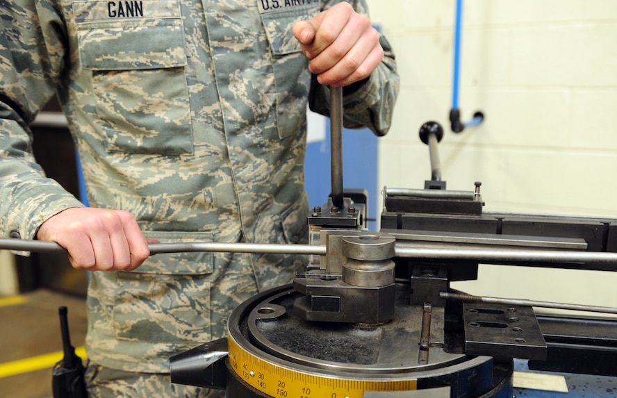 U.S. Air Force Senior Airman Tyler Gann, 7th Equipment Maintenance Squadron aircraft structural maintenance, bends a section of titanium tubing March 26, 2014, at Dyess Air Force Base, Texas. Gann must ensure the tubing size and material is correct for the part being replaced so that it can withstand the pressure of the aircraft’s systems. (U.S. Air Force photo by Senior Airman Kia Atkins/Released)