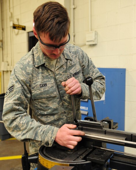 U.S. Air Force Senior Airman Tyler Gann, 7th Equipment Maintenance Squadron aircraft structural maintenance, places a piece of tubing into a tubing bender March 26, 2014, at Dyess Air Force Base, Texas. This particular tube is made of titanium and will be used for repairing a hydraulic pressure line on a B-1B Lancer. (U.S. Air Force photo by Senior Airman Kia Atkins/Released)