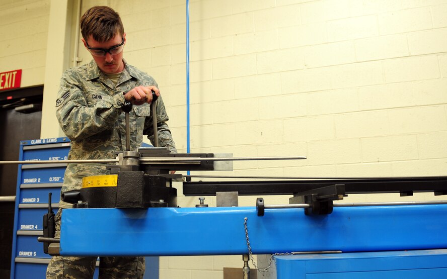 U.S. Air Force Senior Airman Tyler Gann, 7th Equipment Maintenance Squadron aircraft structural maintenance, shapes a new hydraulic line for a B-1B Lancer March 26, 2014, at Dyess Air Force Base, Texas. This machine has the ability to bend tubes varying from .375 to 1.5 inches in diameter. (U.S. Air Force photo by Senior Airman Kia Atkins/Released)