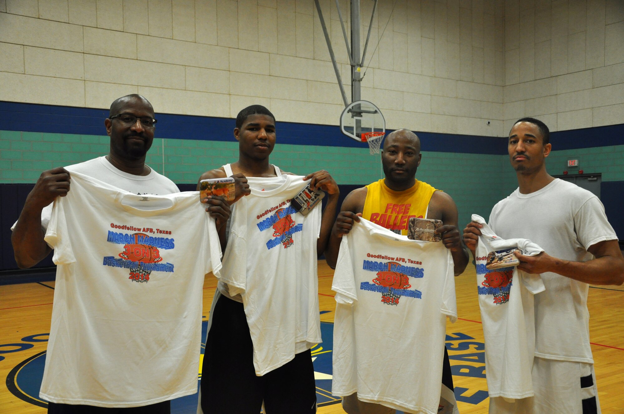 GOODFELLOW AIR FORCE BASE, Texas- Retired Air Force Tech. Sgt. Matthew Moses, Airman 1st Class Reginald D. Peel, 17th Communications Squadron cyber operations journeyman, Staff Sgt. Sharad K. White, 17th CS radio frequency section chief, and Michael Moses, Stay Humbles team member, pose with their winnings from the 2014 Goodfellow March Madness at the Mathis Fitness Center here March 22. Stay Humbles competed against 13 other teams and took home the title. (U.S. Air Force photo/ Airman 1st Class Erica Rodriguez)