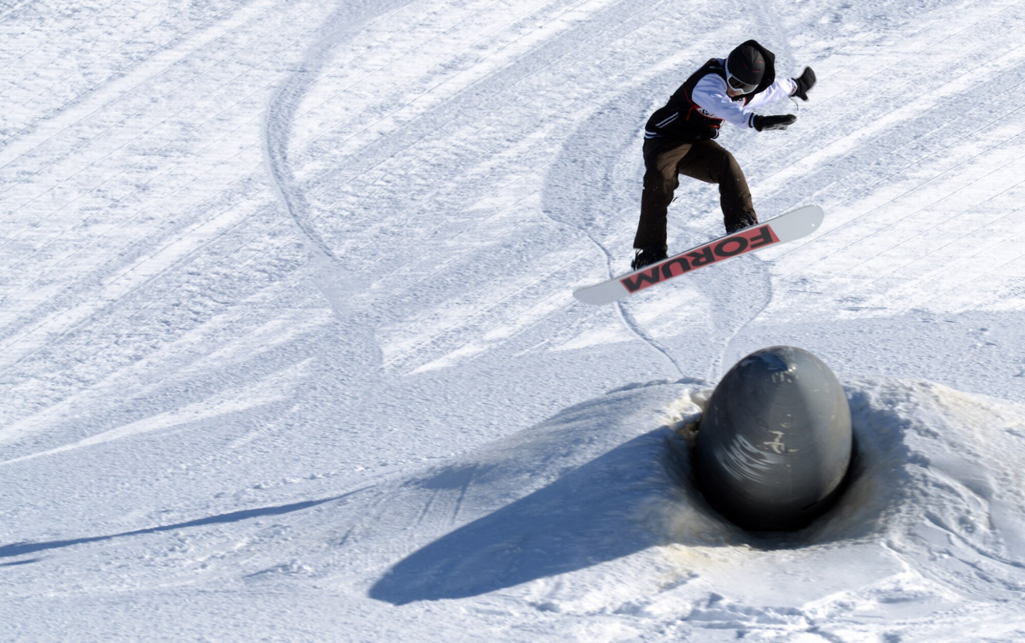 JOINT BASE ELMENDORF-RICHARDSON--Nate Davis, 17, performs a jump off of a buried jet feul tank during the 673d Force Support Squadron?s Spring Meltdown event at the Hillberg Ski Area on Joint Base Elmendorf-Richardson, Alaska, March 22, 2014. The event included a cardboard bobsled race, a terrain park competition, an up-hill/down-hill race and the Slush Cup competition. (U.S. Air Force photo/Staff Sgt. Sheila deVera)
