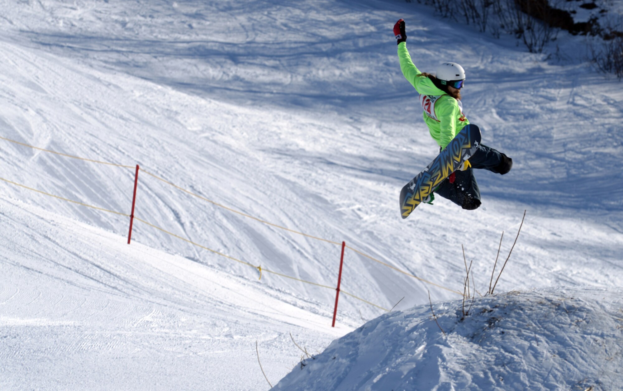 JOINT BASE ELMENDORF-RICHARDSON-- Alex Flores, 19, performs a one-two snowboarding maneuver during the 673d Force Support Squadron?s annual Spring Meltdown terrain park competition at the Hillberg Ski Area on Joint Base Elmendorf-Richardson, Alaska, March 22, 2014. The one-two maneuver is a trick in which the rider?s front hand grabs the heel edge behind his back foot. During the last few days of the ski season various competitions and the annual Slush Cup were held.  (U.S. Air Force photo/Staff Sgt. Sheila deVera)