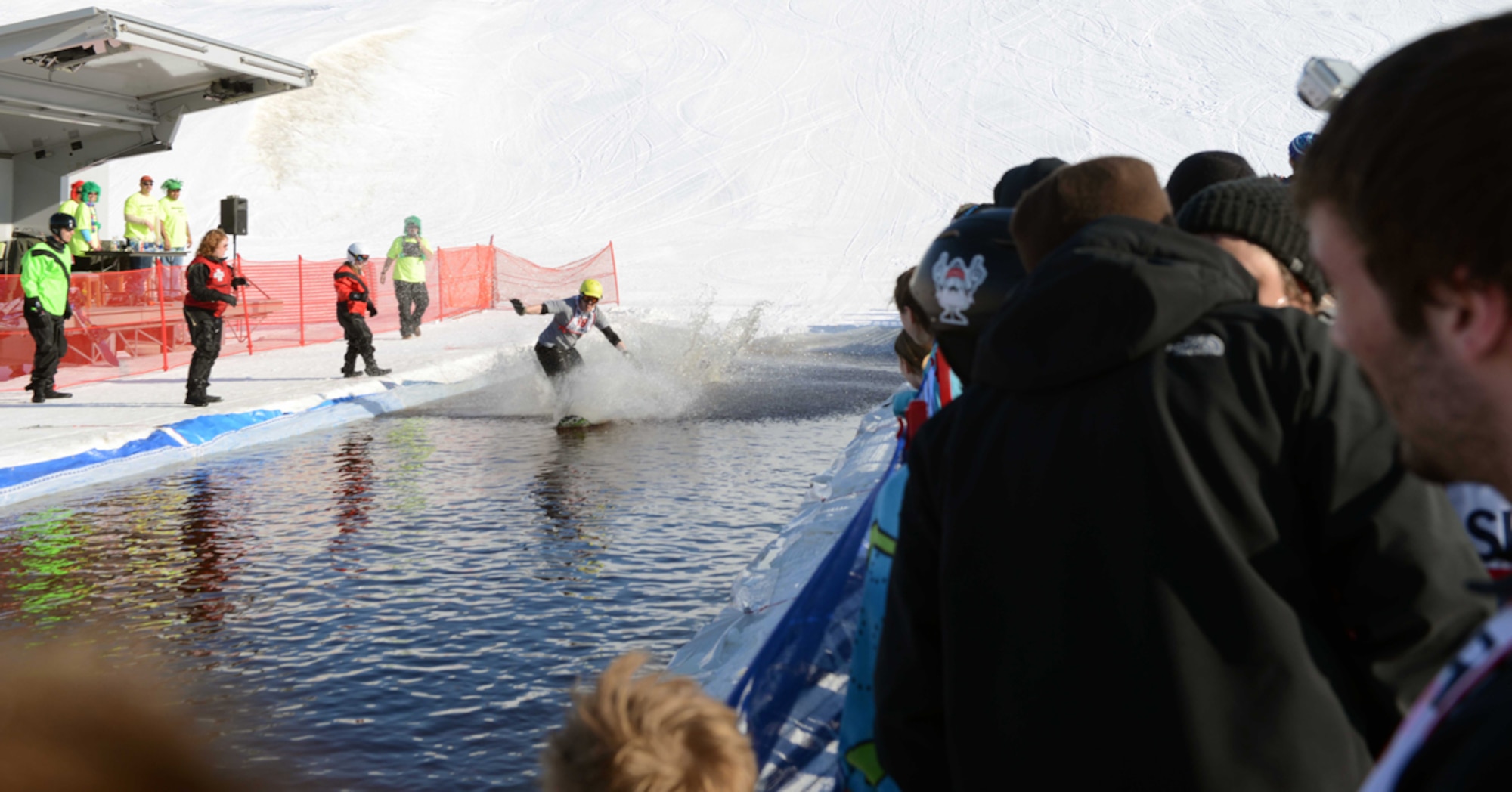 JOINT BASE ELMENDORF-RICHARDSON-- Audience members watch as Shane Thornton glides across water during the Slush Cup 2014 on Joint Base Elmendorf-Richardson, Alaska, March 23, 2014. The Slush Cup is an annual event at the Hillberg Ski Area for all with JBER access to compete for prizes. (U.S. Air Force photo/Airman 1st Class Ty-Rico Lea)