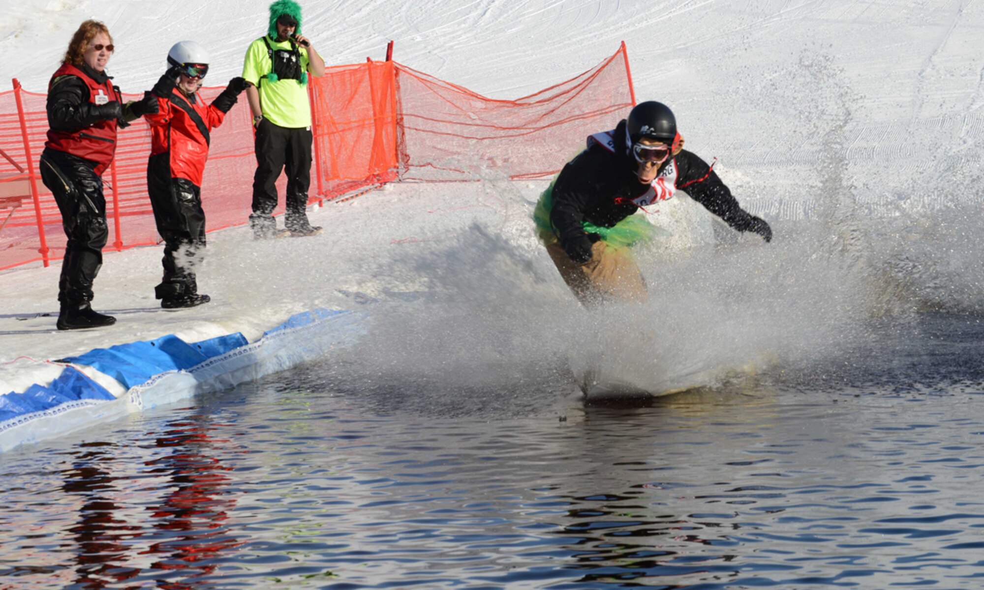 JOINT BASE ELMENDORF-RICHARDSON-- Justin Panter glides across water while wearing a monkey mask at the Slush Cup at the Hillberg Ski Area on Joint Base Elmendorf-Richardson, Alaska, March 23, 2014. Contestants wore various costumes and apparel during the Slush Cup as they competed for higher scores. Panter took first place in the Slush Cup 2014. (U.S. Air Force photo/Airman 1st Class Ty-Rico Lea)