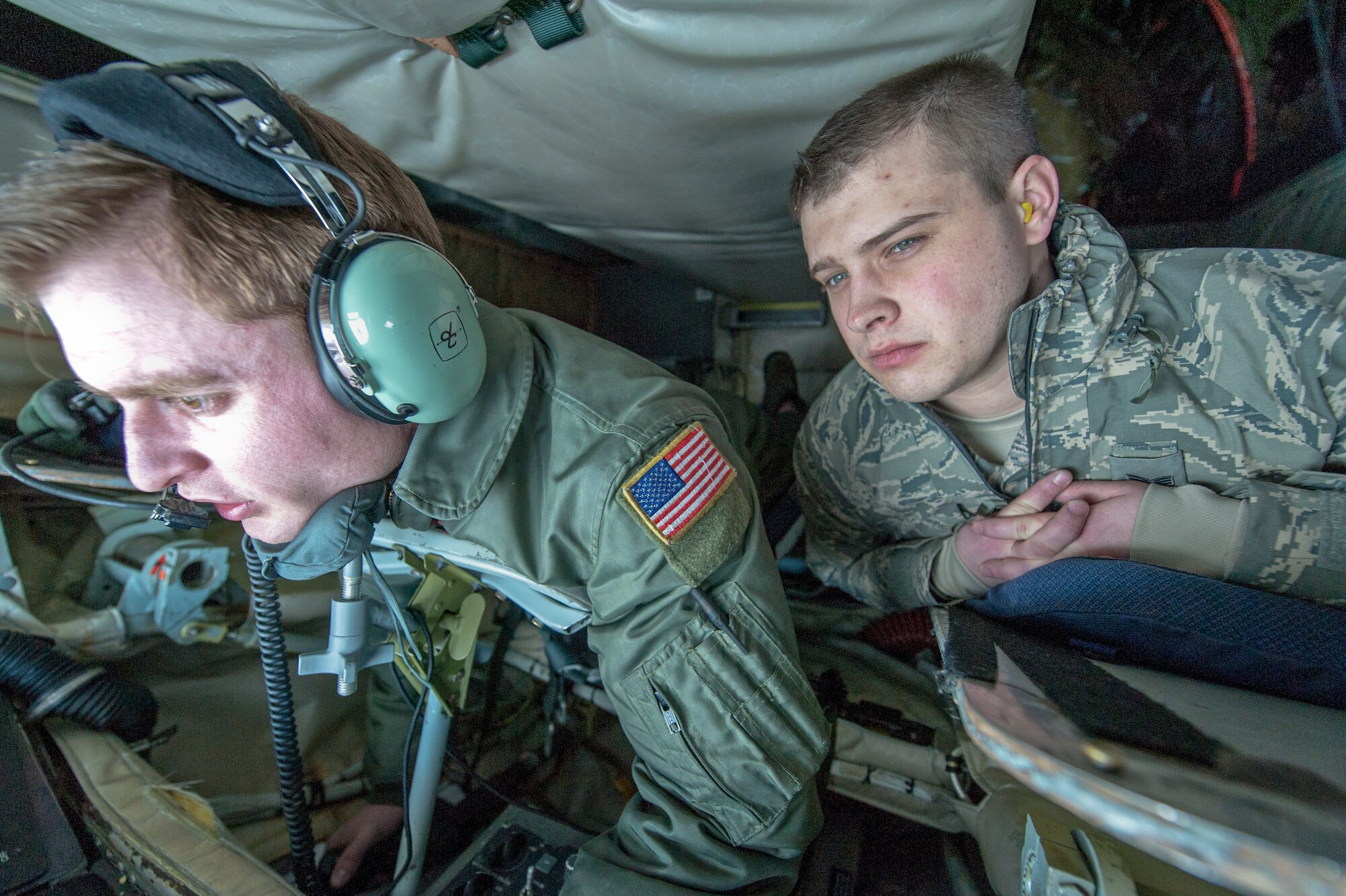 Senior Airman William Forde watches as Staff Sgt. Ryan Kiser makes a boom connection with a KC-10 Extender from Travis Air Force Base, Calif., during an air refueling mission and incentive flight on board a 92nd Air Refueling Wing KC-135 Stratotanker over Oregon and California, March 26, 2014. Incentive flights are designed as an opportunity for pilots and boom operators to show other Airmen the importance they play in fueling the fight for freedom. Kiser is a 92nd Air Refueling Squadron boom instructor and a Rancho Cucamonga, Calif., native. Forde is a 92nd Contracting Squadron contract specialist and hails from Burien, Wash. (U.S. Air Force photo by Staff Sgt. Benjamin W. Stratton)