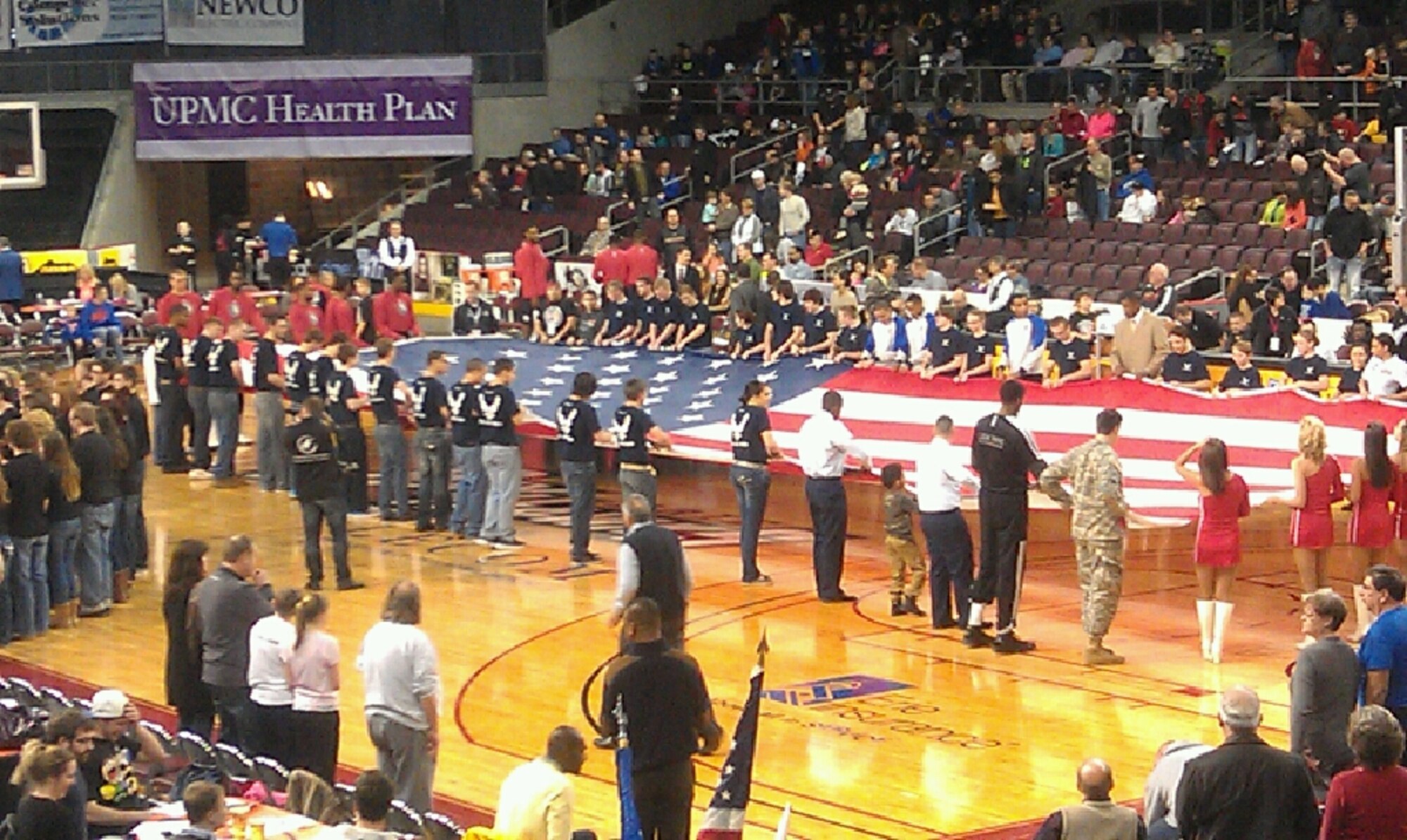 Recruiters and 35 Delayed Entry Program members from the 311th Recruiting Squadron present the U.S. flag to a crowd of more than 3,000 Erie BayHawks basketball fans at a game in Erie, Pa., March 9. The DEP members took the oath of enlistment during the pregame ceremony. (U.S. Air Force photo)
