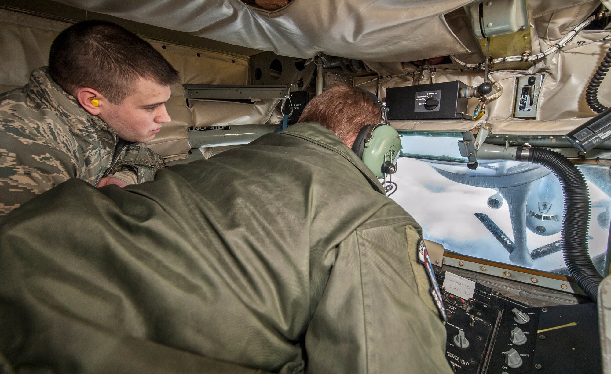 Staff Sgt. Ryan Kiser shows Senior Airman William Forde how he fuels the fight by making a boom connection with a KC-10 Extender from Travis Air Force Base, Calif., during an air refueling mission and incentive flight on board a 92nd Air Refueling Wing KC-135 Stratotanker over Oregon and California, March 26, 2014. Incentive flights are designed as an opportunity for pilots and boom operators to show other Airmen the importance they play in fueling the fight for freedom. Kiser is a 92nd Air Refueling Squadron boom instructor and a Rancho Cucamonga, Calif., native. Forde is a 92nd Contracting Squadron contract specialist and hails from Burien, Wash. (U.S. Air Force photo by Staff Sgt. Benjamin W. Stratton/Released)
