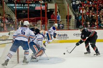Jordan Staal of the Carolina Hurricanes shoots a puck against Edmonton Oilers defenders during a Military Appreciation Day game, March 16, 2014, in Raleigh, N.C.  Throughout the game, the Hurricanes organization took time to honor service members in the crowd for their service to their country.  (U.S. Air Force photo/Airman 1st Class Brittain Crolley)