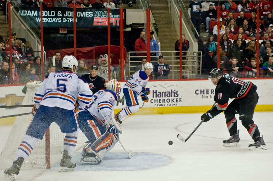 Jordan Staal of the Carolina Hurricanes shoots a puck against Edmonton Oilers defenders during a Military Appreciation Day game, March 16, 2014, in Raleigh, N.C.  Throughout the game, the Hurricanes organization took time to honor service members in the crowd for their service to their country.  (U.S. Air Force photo/Airman 1st Class Brittain Crolley)