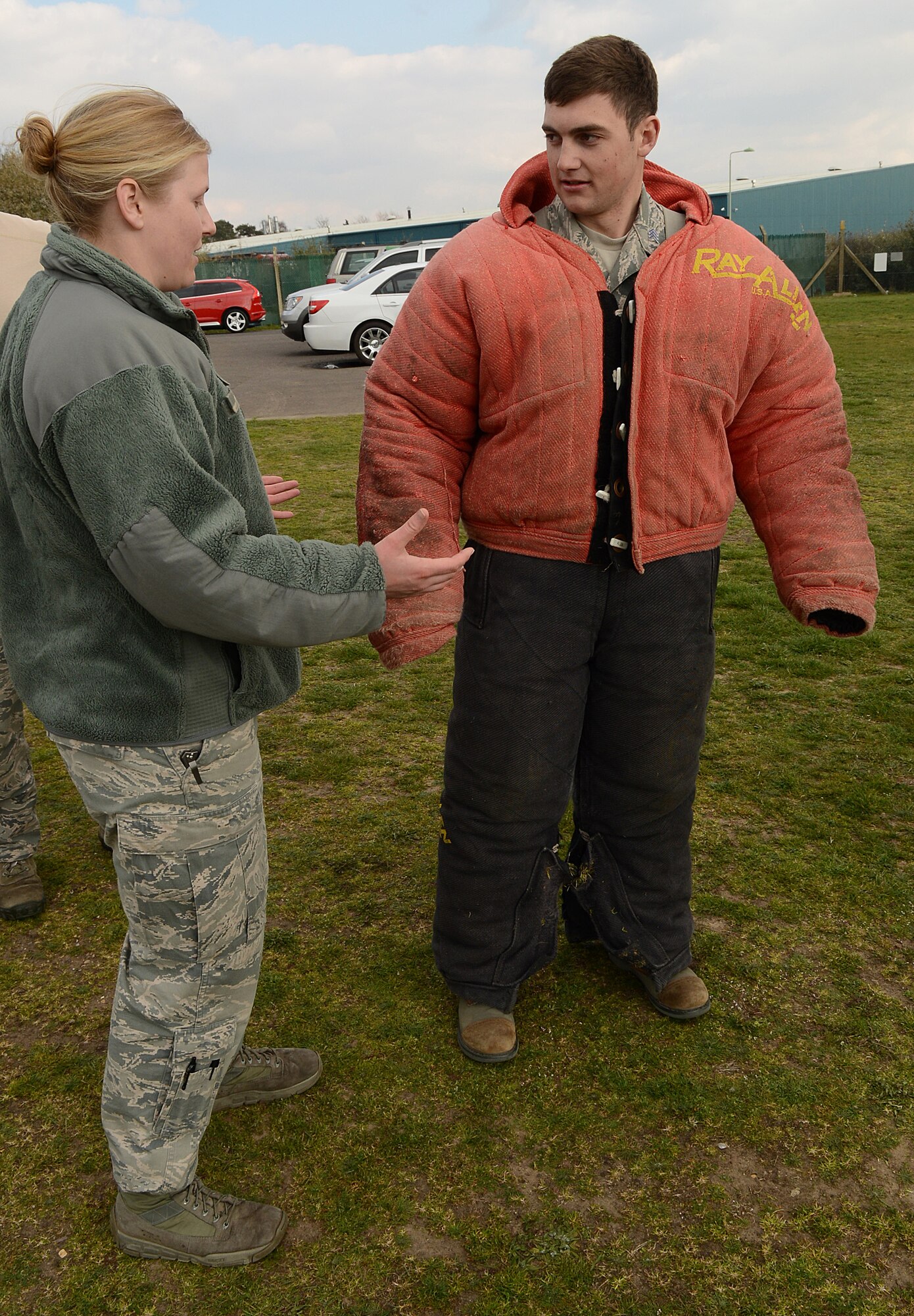 U.S. Air Force Tech. Sgt. Hannah Hobart, left, 100th Security Forces Squadron Military Working Dog kennel master from Aurora, Ind., explains to U.S. Air Force Cadet 2nd Class Matthew Goellnor, U.S. Air Force Academy cadet from Ocean Springs, Miss., the safety precautions of being an MWD training decoy March 25, 2014, on RAF Mildenhall, England. MWD handlers have to complete an optimal training requirement with their dog at least once a work week. MWD teams are instrumental in many areas because of their capability to provide defense for critical buildings and facilities and to deliver a psychological deterrent. (U.S. Air Force photo by Airman 1st Class Jonathan Light/Released)