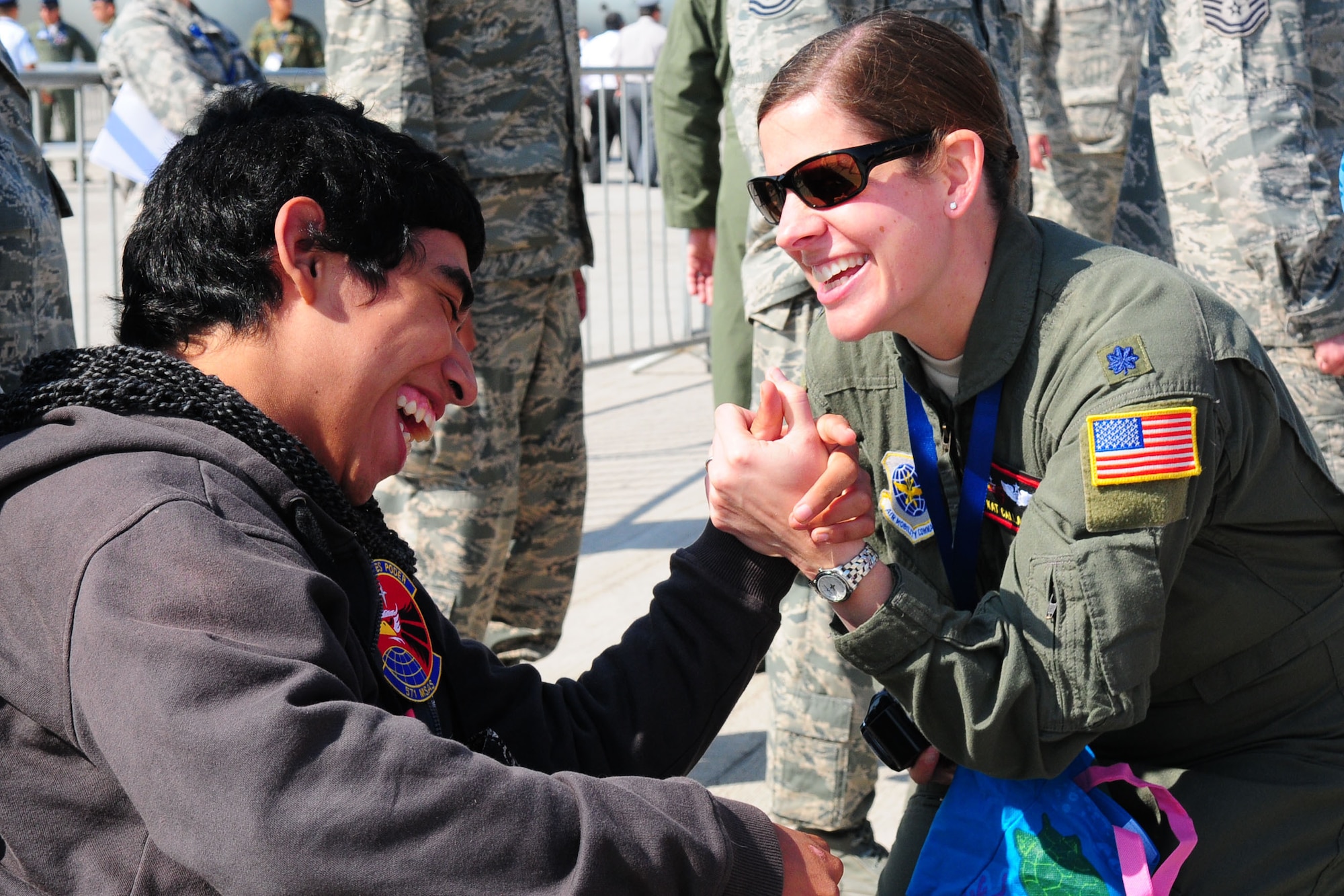 Lt. Col. Kat Callaghan, the 571st Mobility Support Advisory Squadron director of operations, spends time with a Chilean boy from the Telet?n Foundation at the FIDAE Air Show in Santiago, Chile, March 26. Nearly 60 U.S. airmen are participating in subject matter expert exchanges with Chilean air force counterparts during FIDAE, and as part of the events are hosting static displays of the C-130 Hercules and F-16. Airmen from the Texas Air National Guard set aside time to host the children before the public days of FIDAE, which are scheduled for the weekend. (U.S. Air Force photo by Senior Master Sgt. Miguel Arellano/Released)