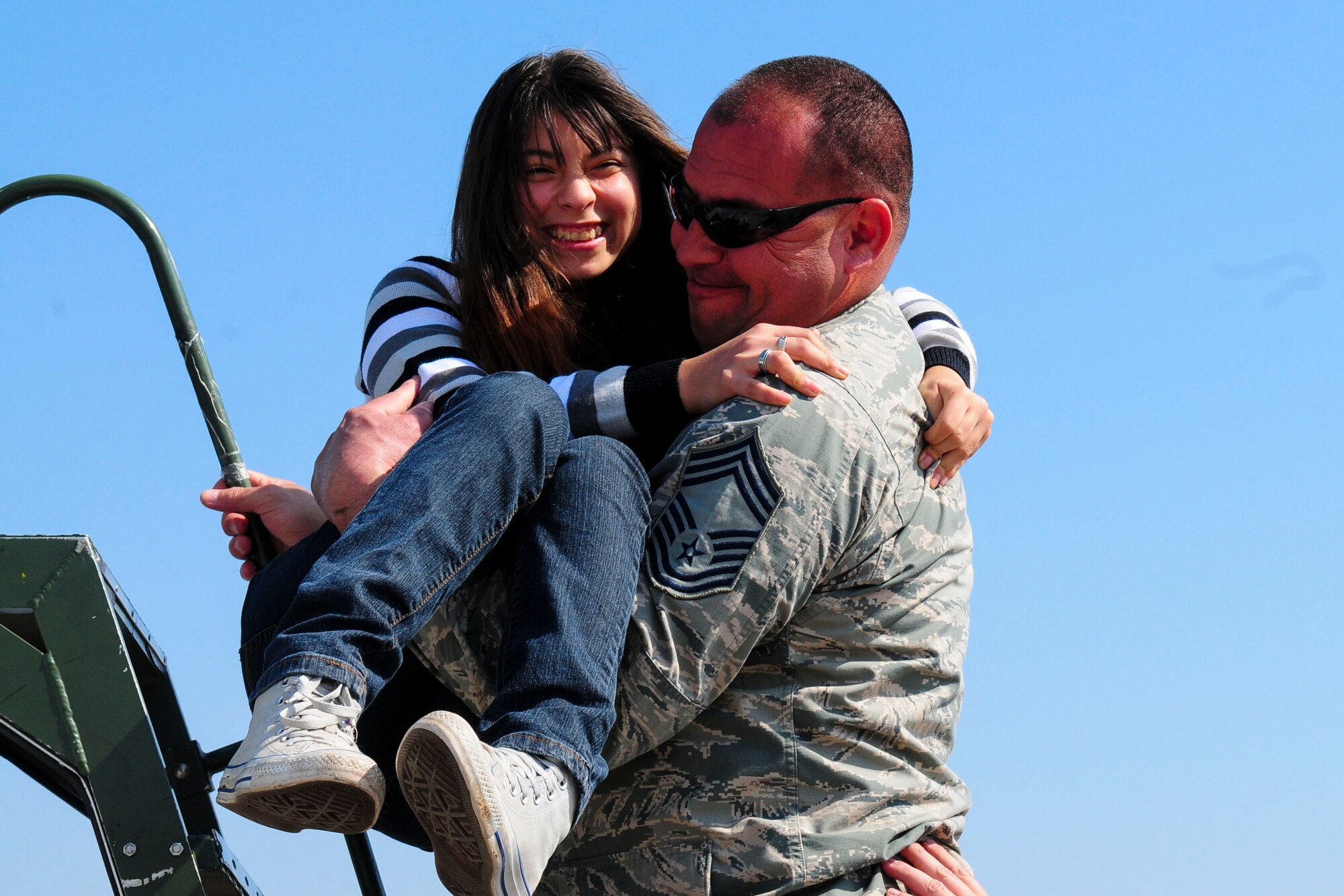 Chief Master Sgt. Caesar Acosta, an aircraft maintenance specialist for the Texas Air National Guard, carries a wheelchair-bound Chilean girl up stairs to look inside the cockpit of a U.S. F-16 Fighting Falcon at the FIDAE Air Show in Santiago, Chile, March 26.  Nearly 60 U.S. airmen are participating in subject matter expert exchanges with Chilean air force counterparts during FIDAE, and as part of the events are hosting static displays of the C-130 Hercules and F-16.  Airmen from the Texas Air National Guard set aside time to host the children before the public days of FIDAE, which are scheduled for the weekend. (U.S. Air Force photo by Senior Master Sgt. Miguel Arellano/Released)