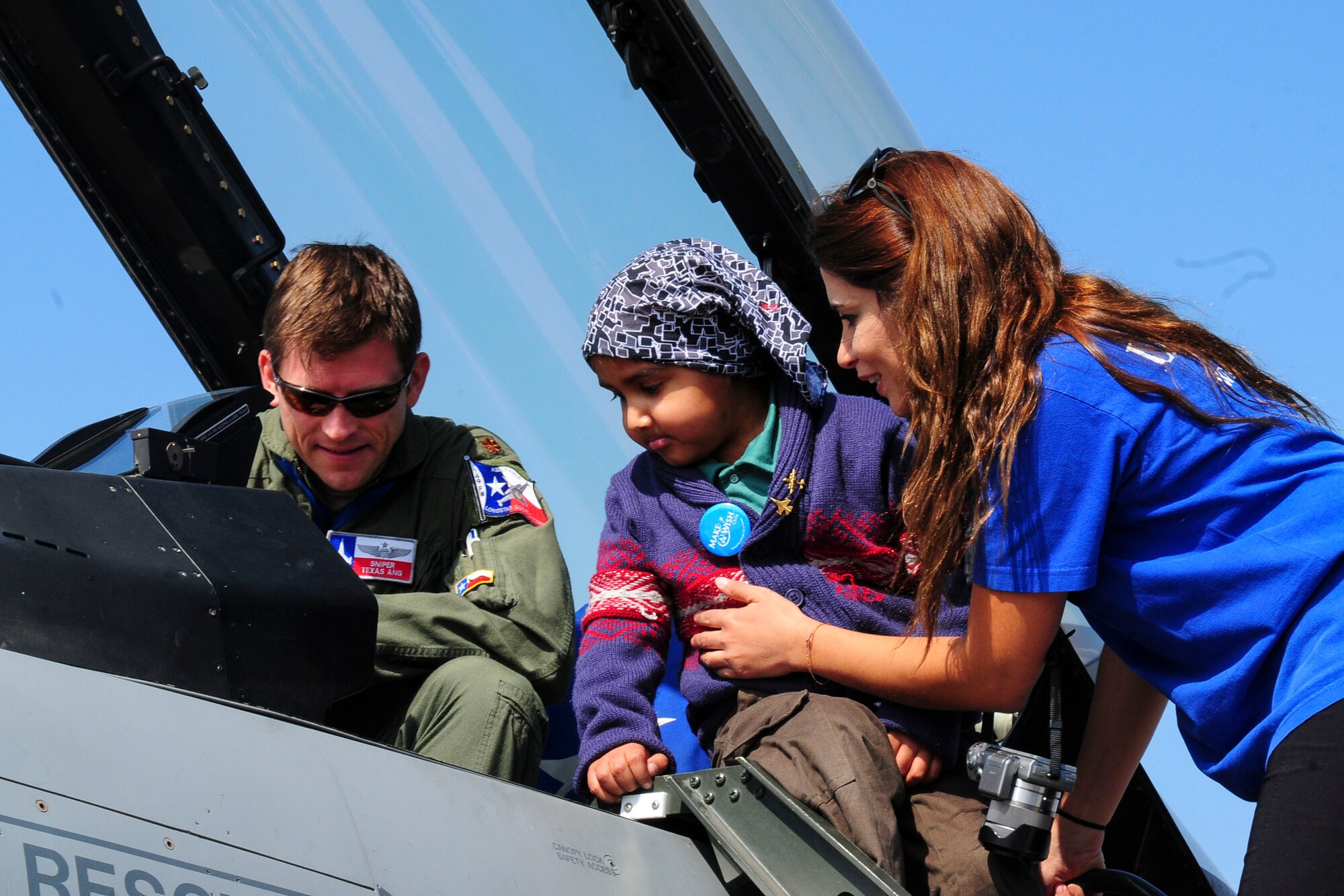 Maj. Steve Fargo, a fighter pilot for the Texas Air National Guard, shows off the F-16 Fighting Falcon to a girl from the Make-A-Wish Foundation at the FIDAE Air Show in Santiago, Chile, March 26. Nearly 60 U.S. airmen are participating in subject matter expert exchanges with Chilean air force counterparts during FIDAE, and as part of the events are hosting static displays of the C-130 Hercules and F-16. Airmen from the Texas Air National Guard set aside time to host the children before the public days of FIDAE, which are scheduled for the weekend. (U.S. Air Force photo by Senior Master Sgt. Miguel Arellano/Released)