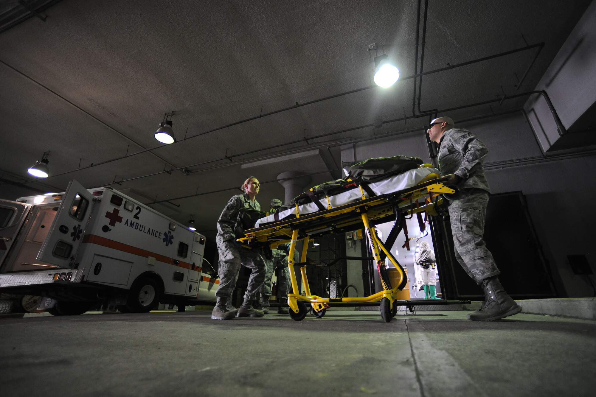 Tech Sgt. Kelly Gamez, 39th Medical Operations Squadron NCO in charge of the personnel readiness program and flight medicine, and Senior Airman Wilford Melton, 39th MDOS medical technician, lower a gurney during an exercise March 25, 2014, Incirlik Air Base, Turkey.  Emergency response teams and base agencies participated in a readiness exercise which simulated Airmen being injured and exposed to radiation. (U.S. Air Force photo by Senior Airman Nicole Sikorski/Released)