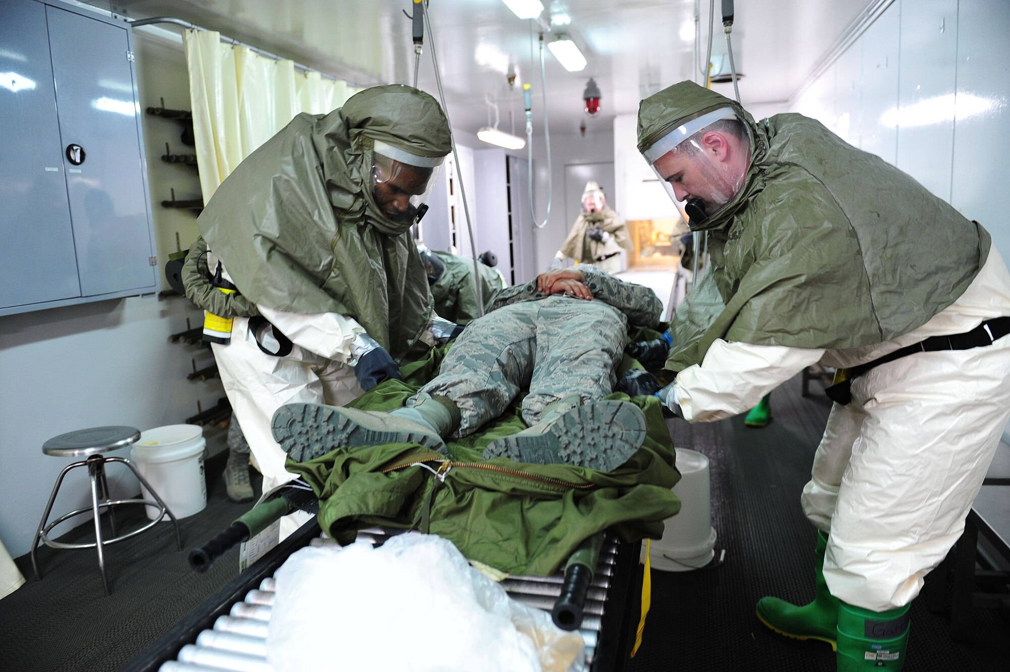 Tech Sgt. Jason Atkins, 39th Medical Operations Squadron NCO in charge of the dental clinic support element, and Tech. Sgt Kenneth Gately, 39th Medical Operations Squadron NCO in charge of laboratory services, demonstrate decontaminate procedures for an Airman simulated as being exposed to radiation during a readiness exercise March 25, 2014, Incirlik Air Base, Turkey.   Airmen from the 39th Air Base Wing exercise regularly to remain prepared for real-world emergencies and contingency operations. (U.S. Air Force photo by Senior Airman Nicole Sikorski/Released) 