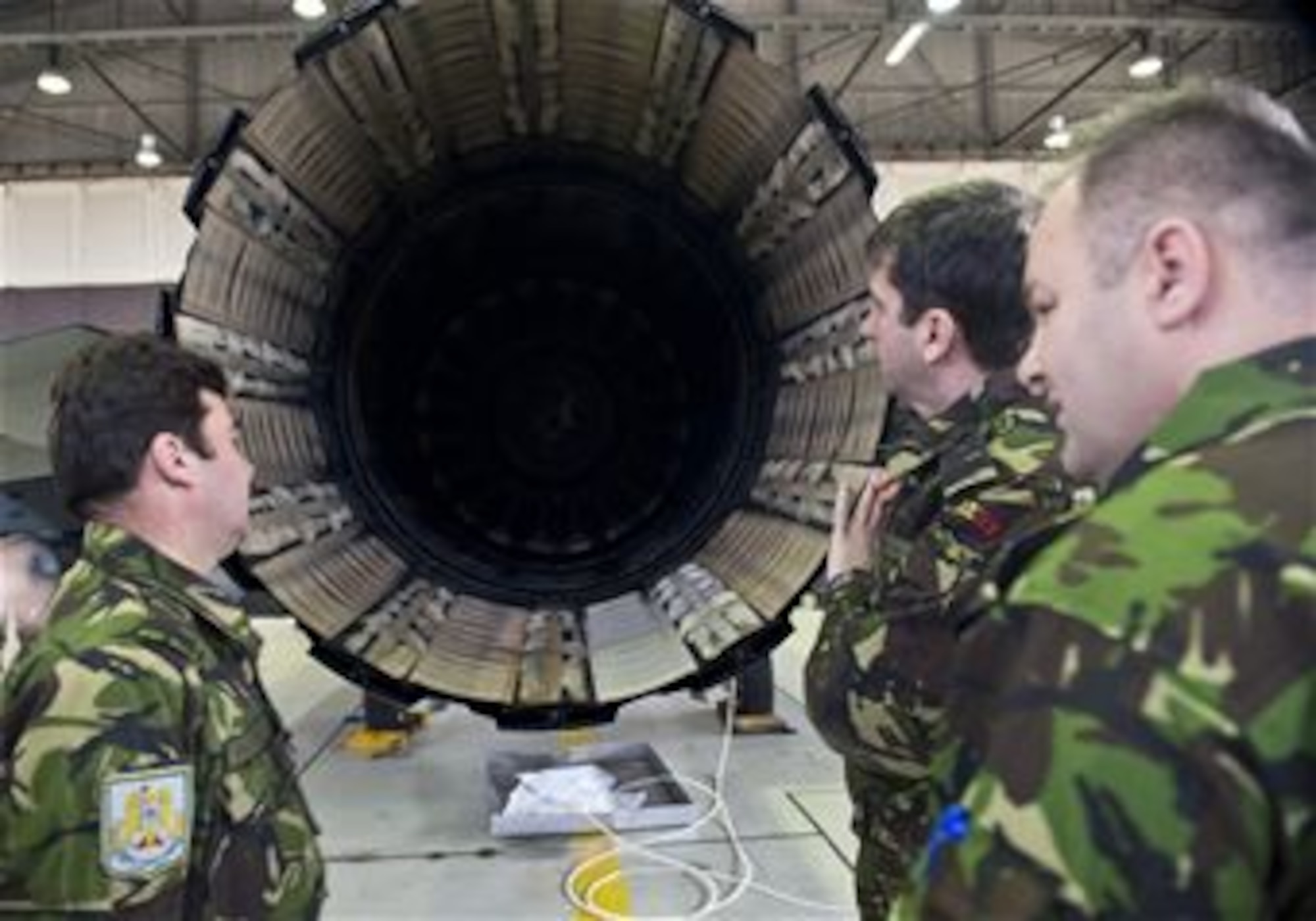 Romanian air force members examine the engine exhaust nozzle of an F-16 Fighting Falcon fighter aircraft during a familiarization tour at Spangdahlem Air Base, Germany, March 25, 2014. The purpose of the visit was for Romanian air force officials to observe the structure and operation of an F-16 squadron before laying the framework for their transition from the MiG-21 fighter aircraft. (U.S. Air Force photo by Staff Sgt. Chad Warren/Released)