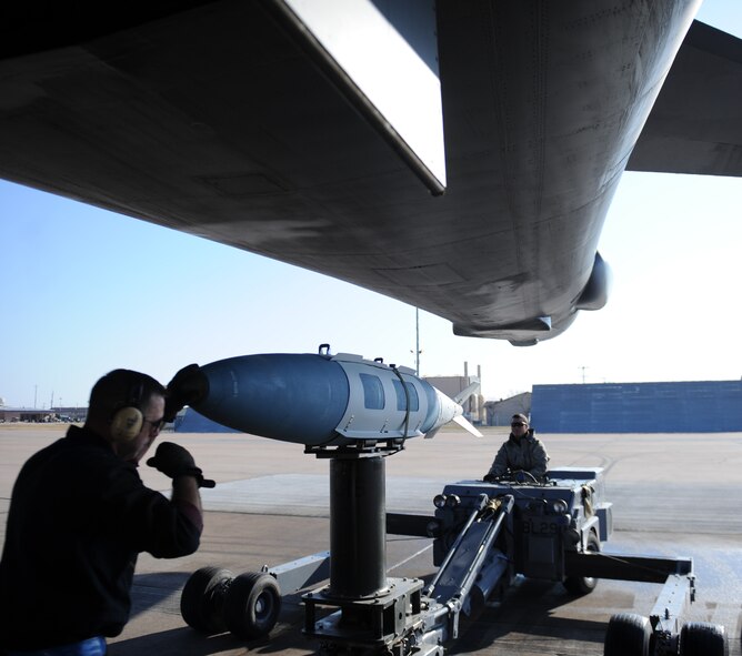 U.S. Air Force Senior Airman Austin Anderson, right, and Tech Sgt. Charles Winkelspecht, both from the 7th Aircraft Maintenance Squadron weapons flight, prepare to load a global positioning system-guided bomb unit onto a B-1B Lancer March 25, 2014, at Dyess Air Force Base, Texas.  GPS-guided bombs operate by satellite coordinates. The fins on the back of the bomb shift to change its direction to ensure accuracy while it’s moving. (U.S. Air Force photo by Airman 1st Class Kedesha Pennant/Released)