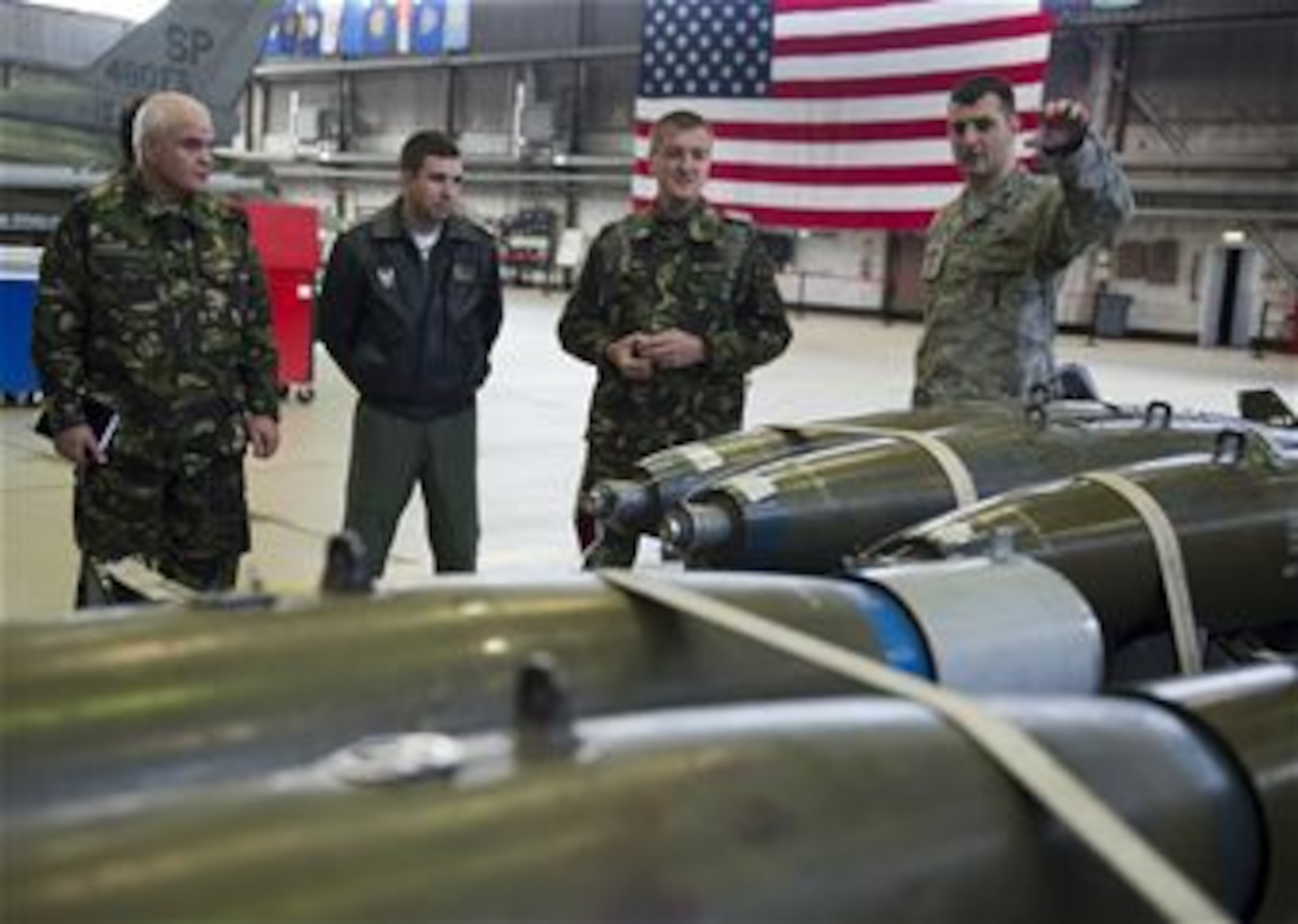 U.S. Air Force Capt. Warren Smith, 52nd Maintenance Group maintenance operations officer in charge, explains weapon capabilities to members of the Romanian air force during a familiarization tour at Spangdahlem Air Base, Germany, March 25, 2014. The visit was the first in a series of engagements aimed at helping the Romanian air force stand up their first F-16 Fighting Falcon fighter aircraft squadron. (U.S. Air Force photo by Staff Sgt. Chad Warren/Released)