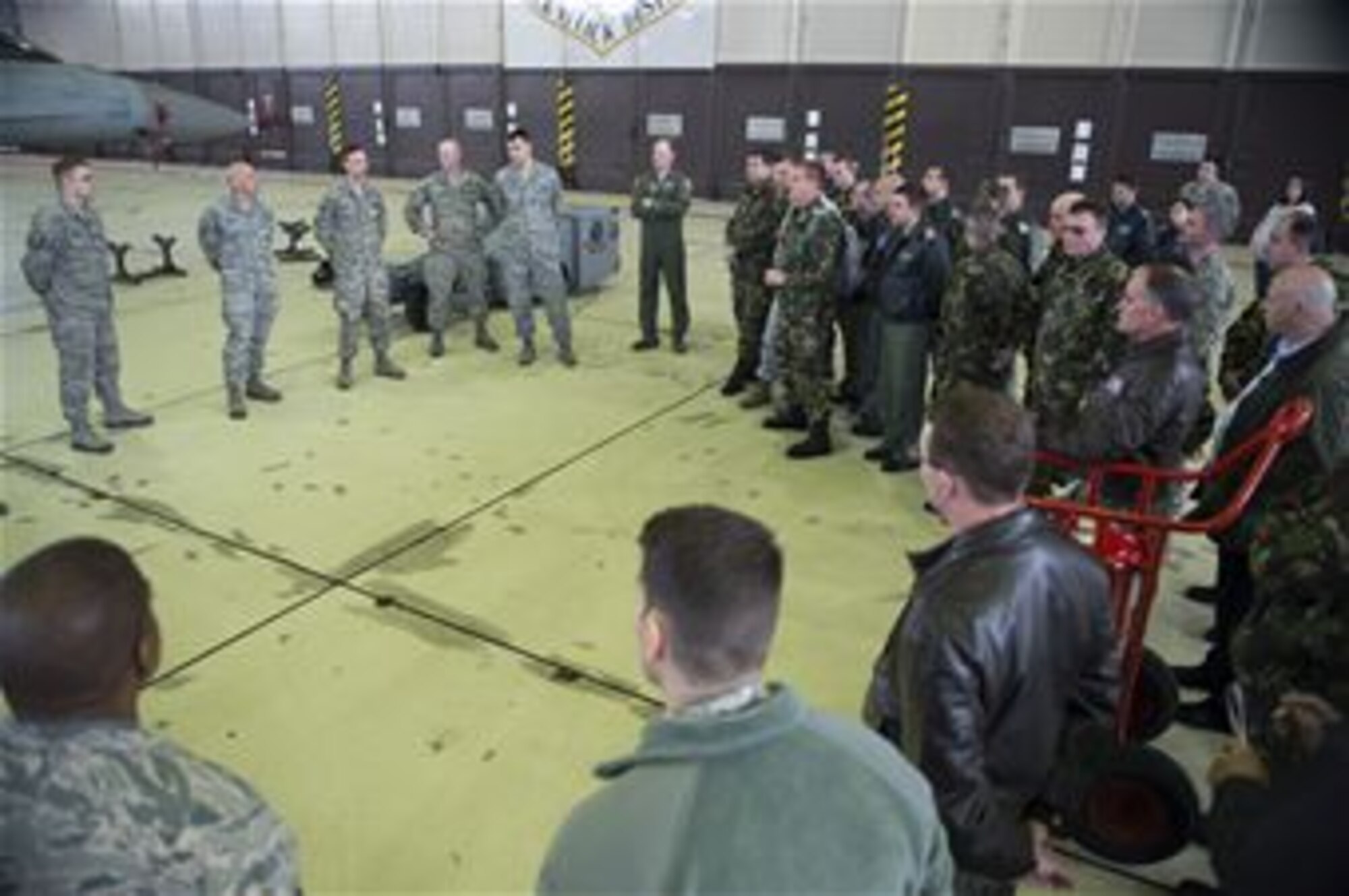 U.S. and Romanian air force members discuss F-16 Fighting Falcon fighter aircraft weapons capabilities at Spangdahlem Air Base, Germany, March 25, 2014. Romanian air force officials toured the 52nd Fighter Wing in order to familiarize themselves with the operations, maintenance and support of a fully operational F-16 squadron. (U.S. Air Force photo by Staff Sgt. Chad Warren/Released)