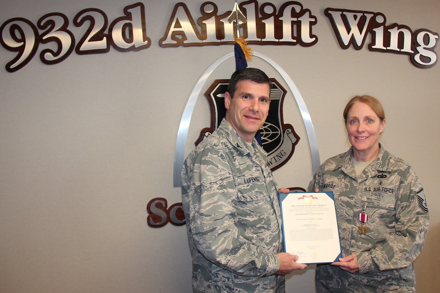 The 932nd Airlift Wing's commander, Col. Albert Lupenski, presented recruiter Master Sgt. Kimberly McBride with a Meritorious Service Medal for outstanding service to the Air Force Reserve Recruiting Service.  During the period of 2009-2012 she recruited 162 Airmen while attaining 139 percent of goal, earning her the esteemed Century Club Award.  (U.S. Air Force photo/Maj. Stan Paregien)