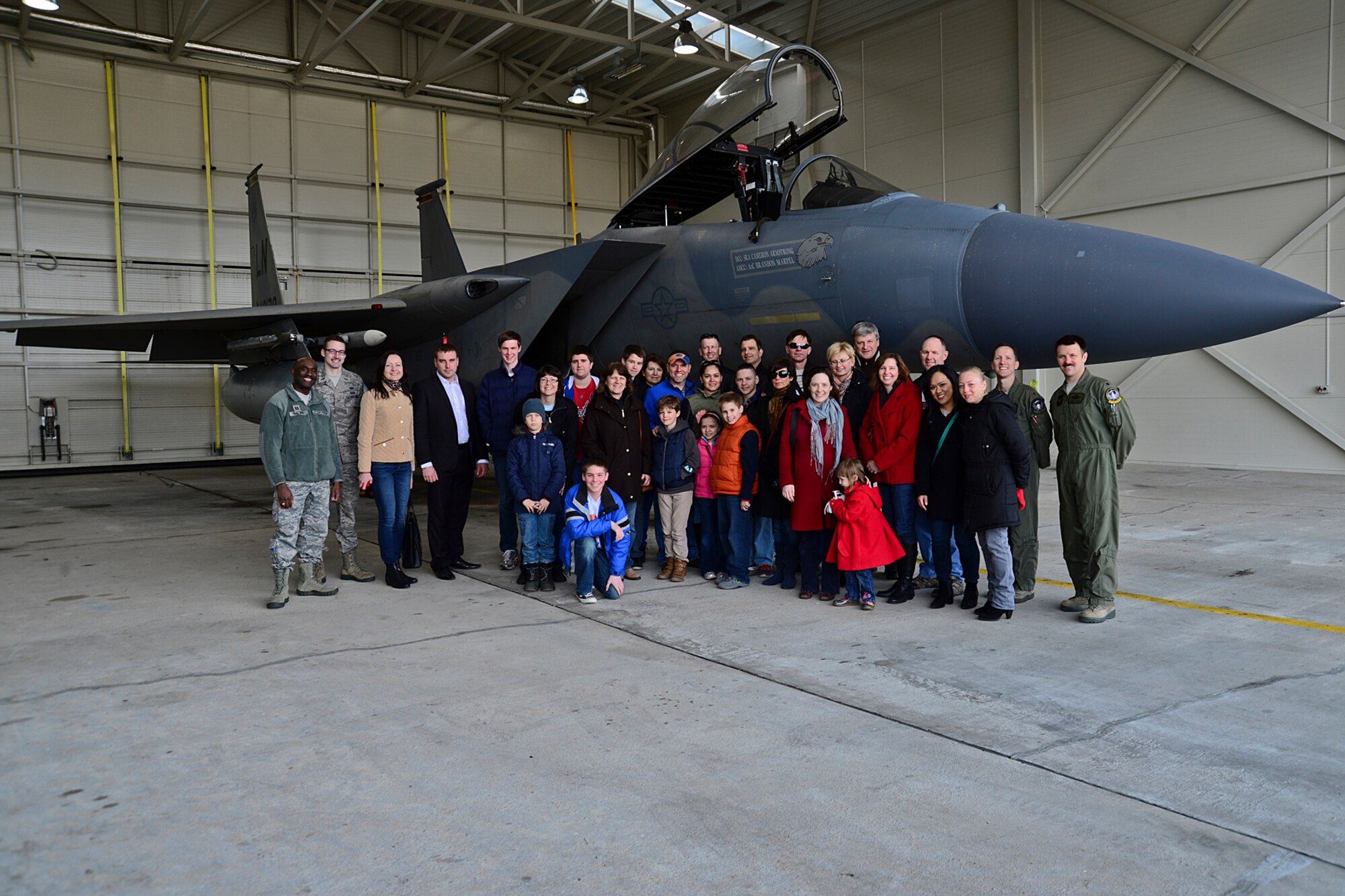 United States Embassy Vilnius officials and their families pose for a photo in front of an F-15C Eagle at Šiauliai Air Base, Lithuania, March 22, 2014. The 48th Air Expeditionary Group conducts tours to showcase its capabilities and educate members of the public on the NATO Baltic Air Policing mission. (U.S. Air Force photo by Airman 1st Class Dana J. Butler/Released)
