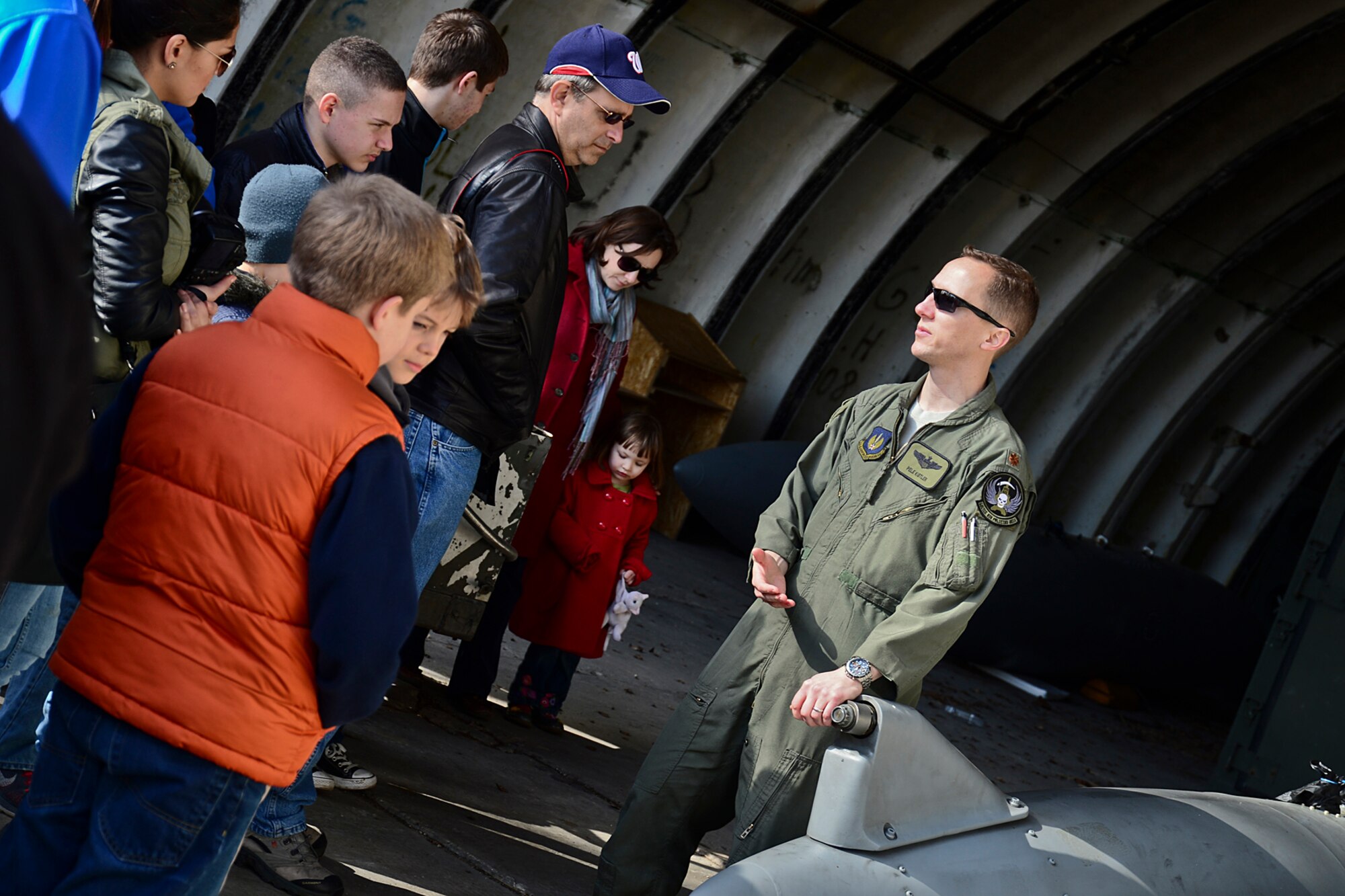 Major Charles Kistler, 493rd Expeditionary Fighter Squadron pilot, talks about external fuel tanks to U.S. Embassy Vilnius officials and their families while conducting a tour at Šiauliai Air Base, Lithuania, March 22, 2014. The 48th Air Expeditionary Group conducts tours to showcase its capabilities and educate members of the public on the NATO Baltic Air Policing mission. (U.S. Air Force photo by Airman 1st Class Dana J. Butler/Released)